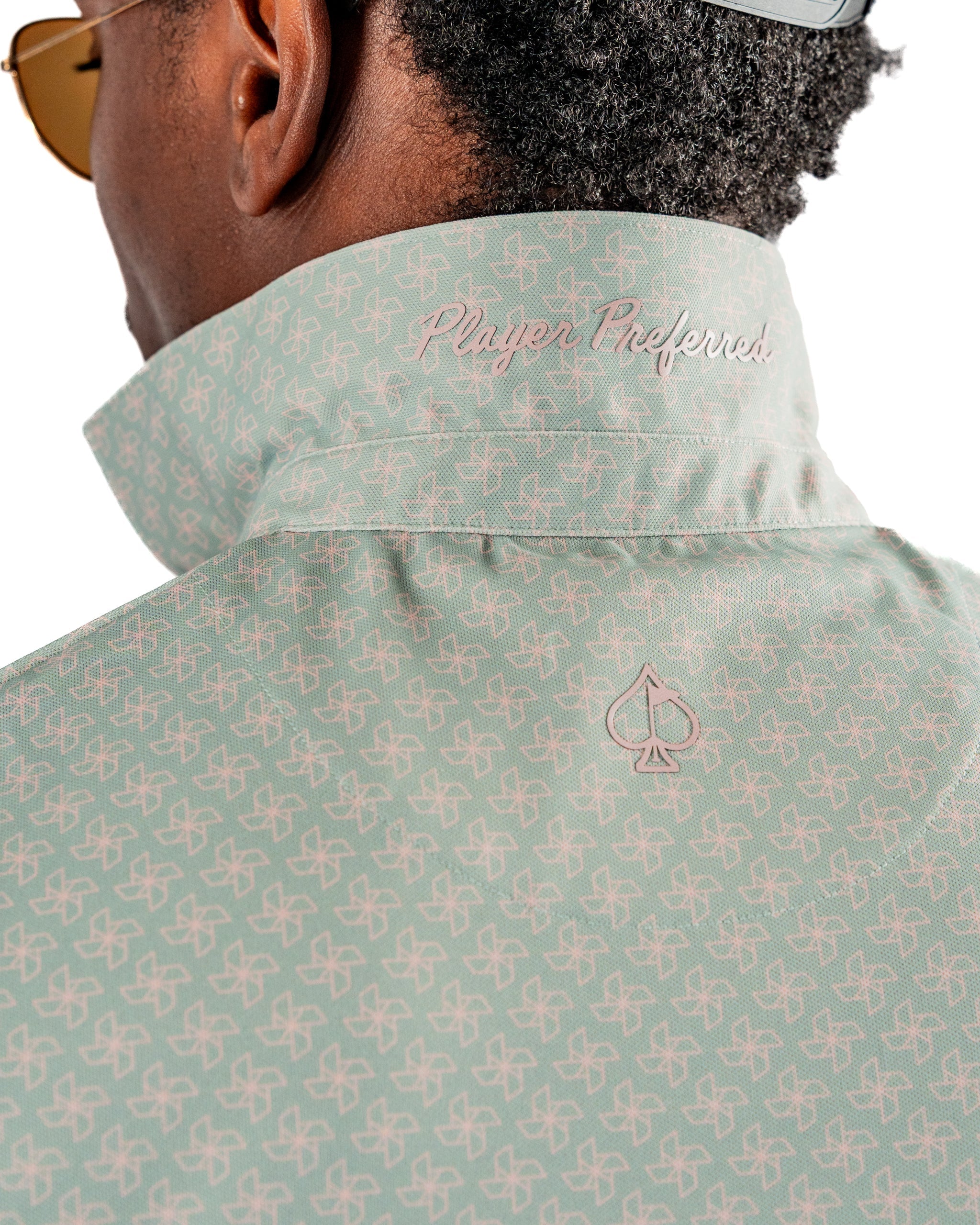 Men's golf shirt featuring a stylish origami pattern, with a raised collar and "Player Preferred" embroidery on the back.