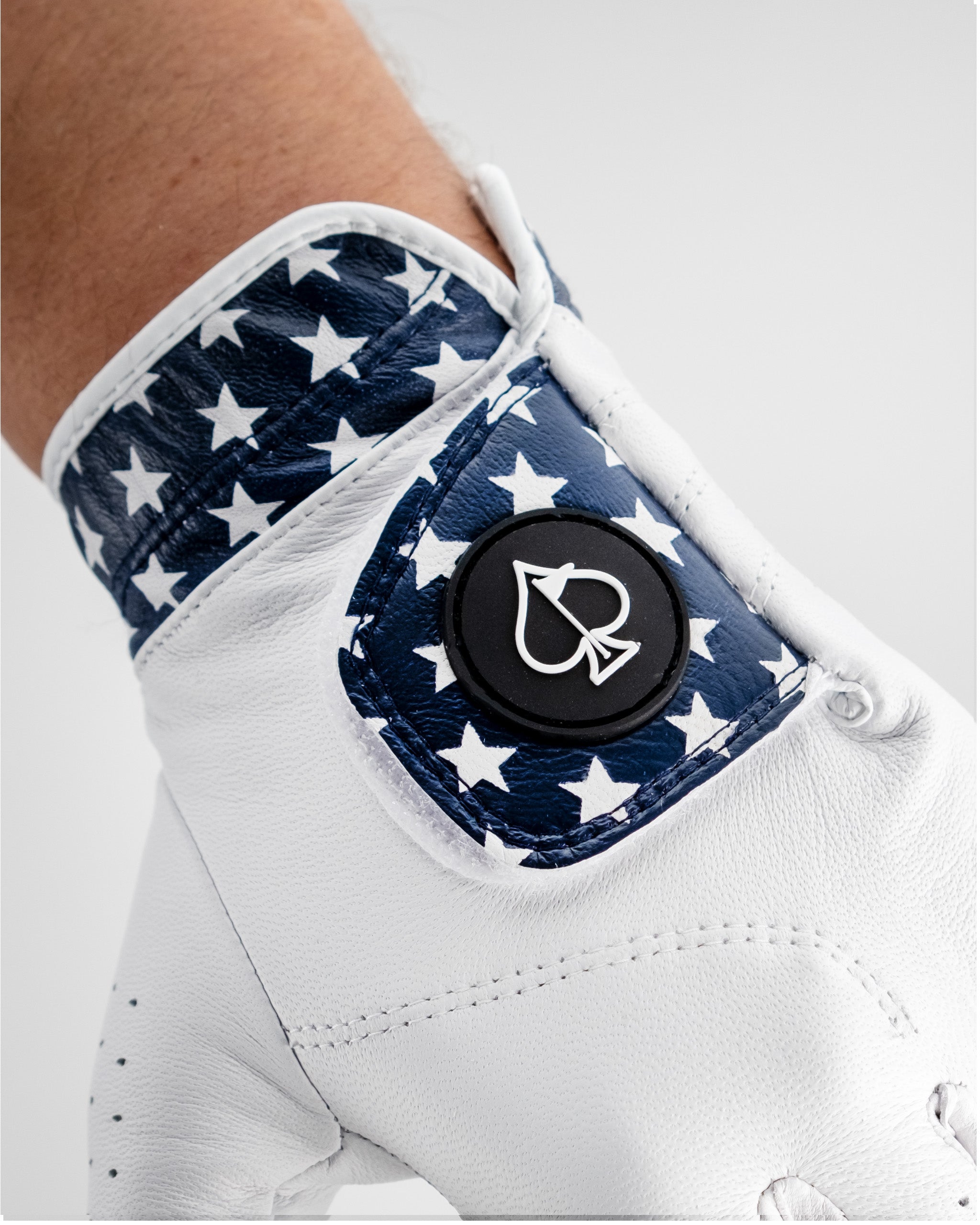 Premium golf glove featuring a navy blue design with white stars and a bold logo on the wrist for a stylish look on the course.