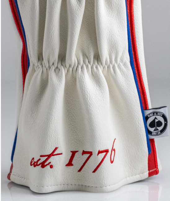 Betsy Ross driver cover featuring a white leather design with red and blue stripes and "est. 1776" embroidered.
