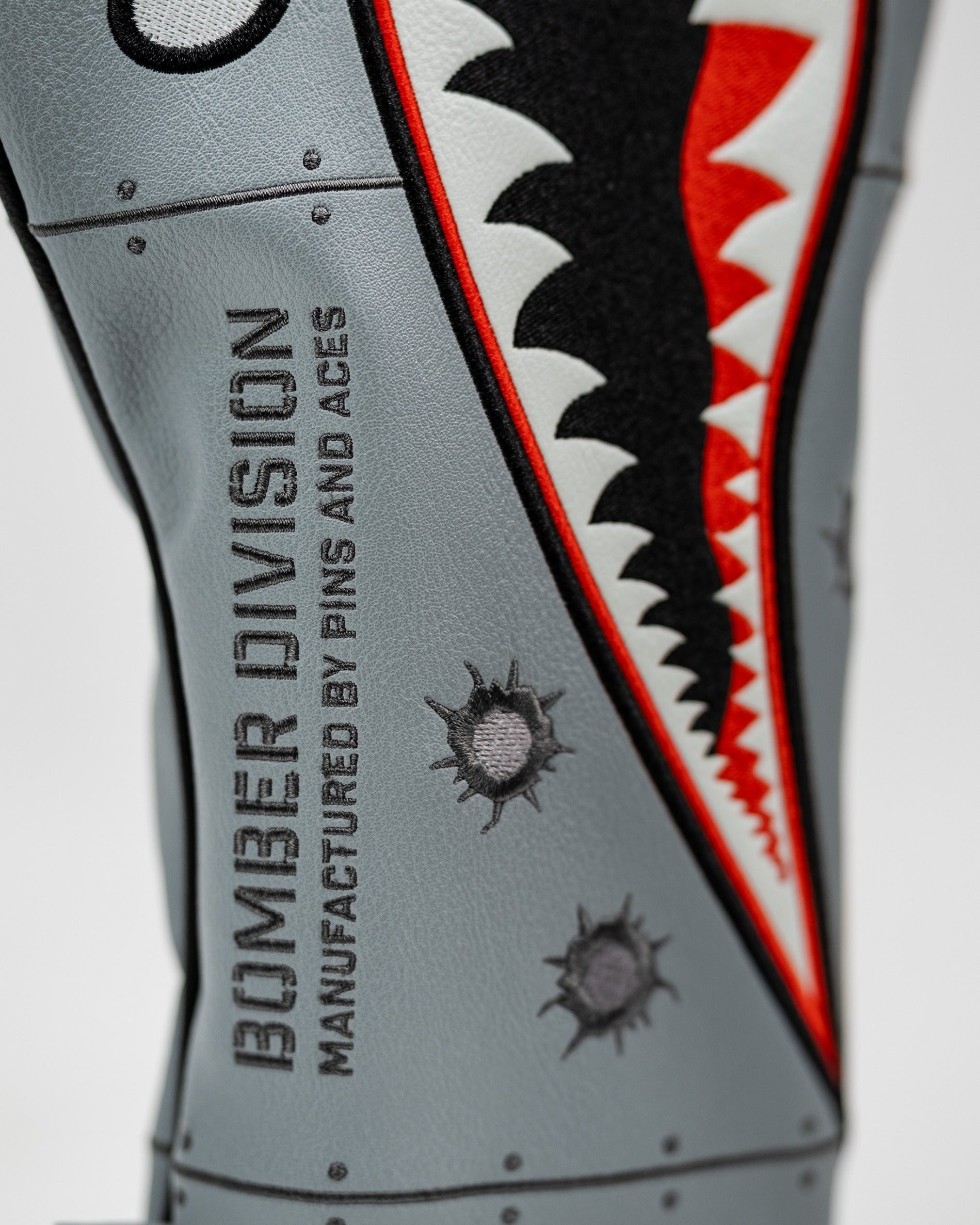 Bold bomber-style driver cover featuring shark graphics and embroidered details, designed for standout golf performance.
