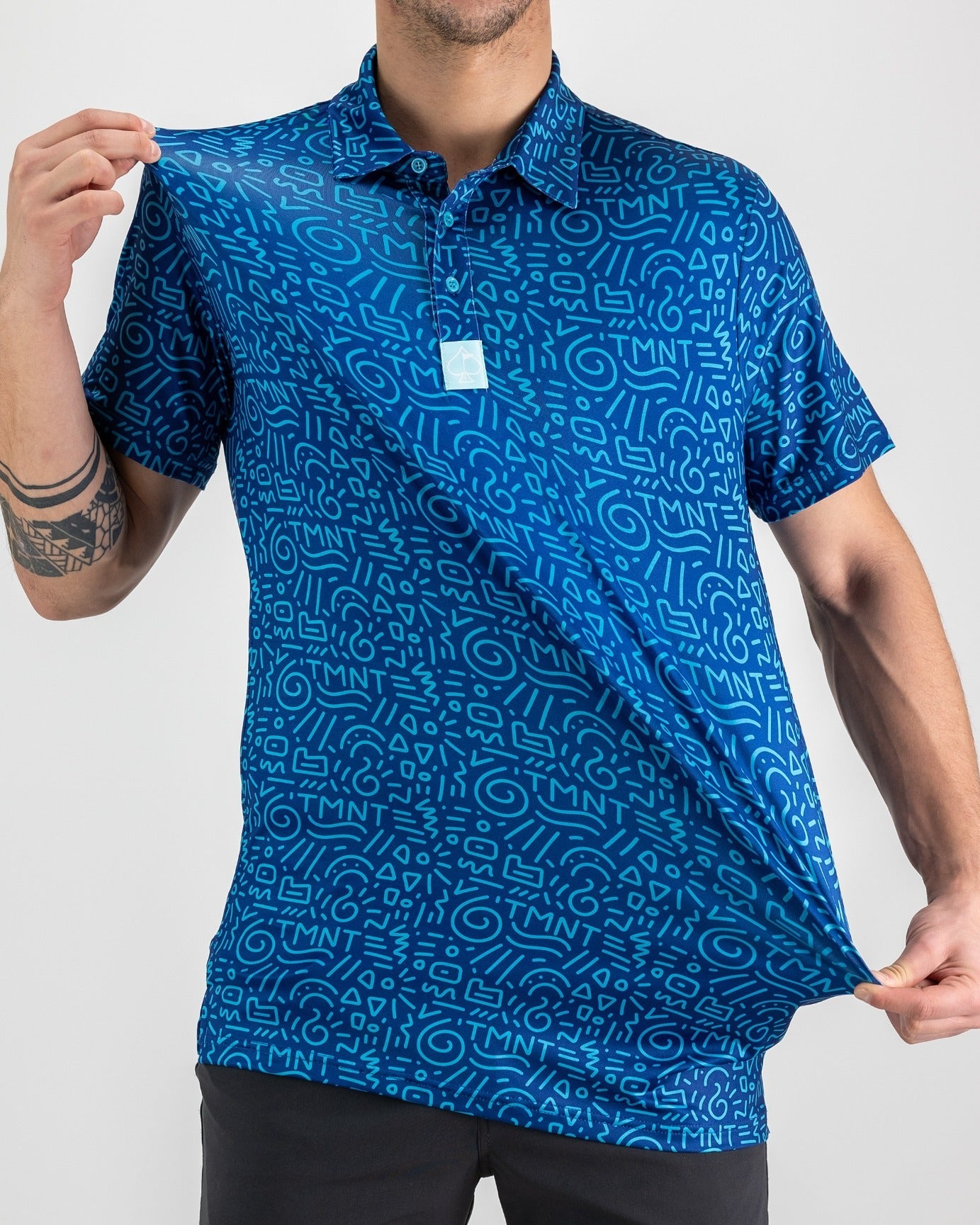 Men's blue polo shirt featuring a playful TMNT doodle pattern, showcasing a vibrant design perfect for golf enthusiasts.