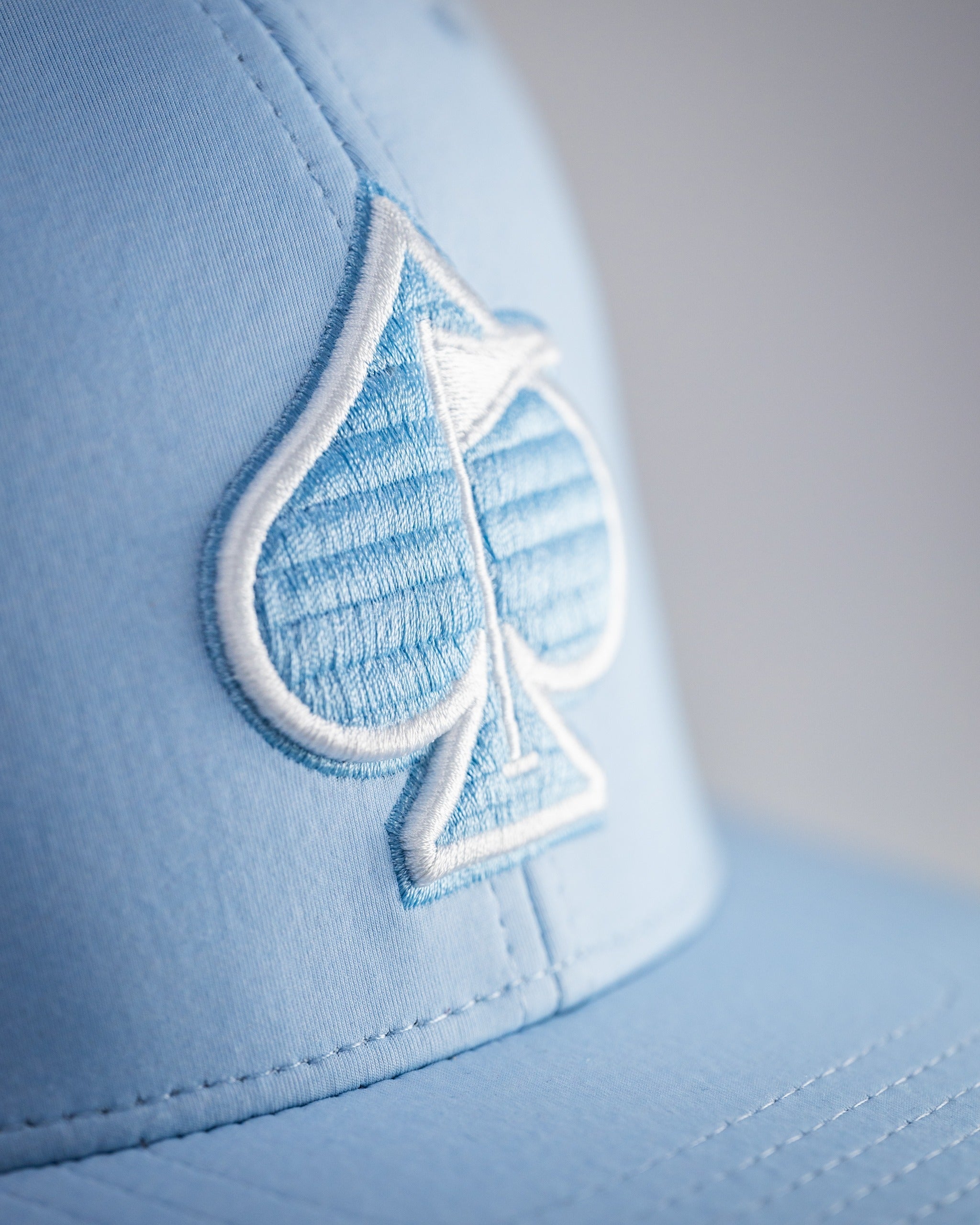 Carolina Blue Performance Spade Hat featuring an embroidered spade logo, designed for stylish golfers on the course.