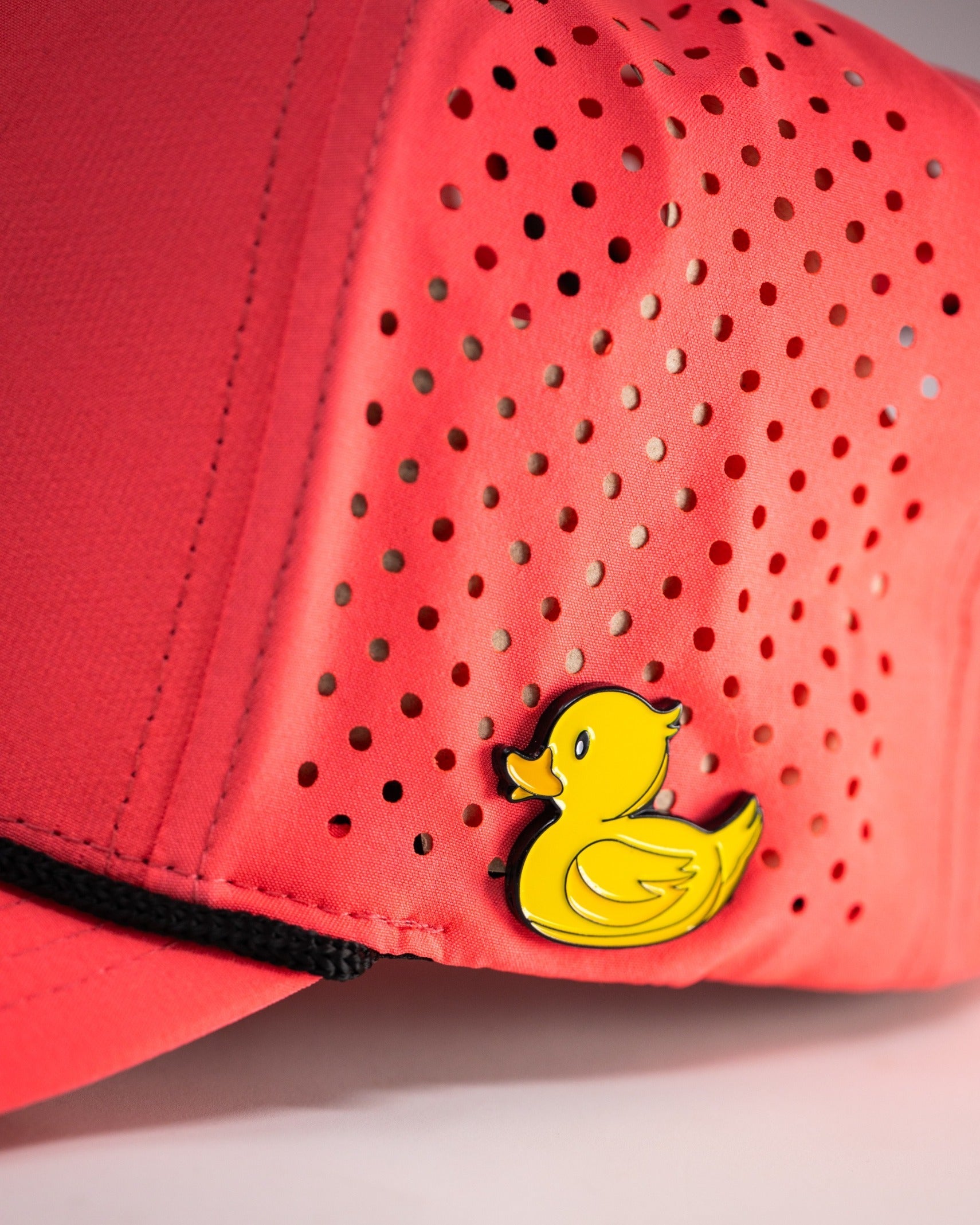 Highlighter pink perforated rope hat featuring a playful yellow duck emblem, perfect for bold golfers.