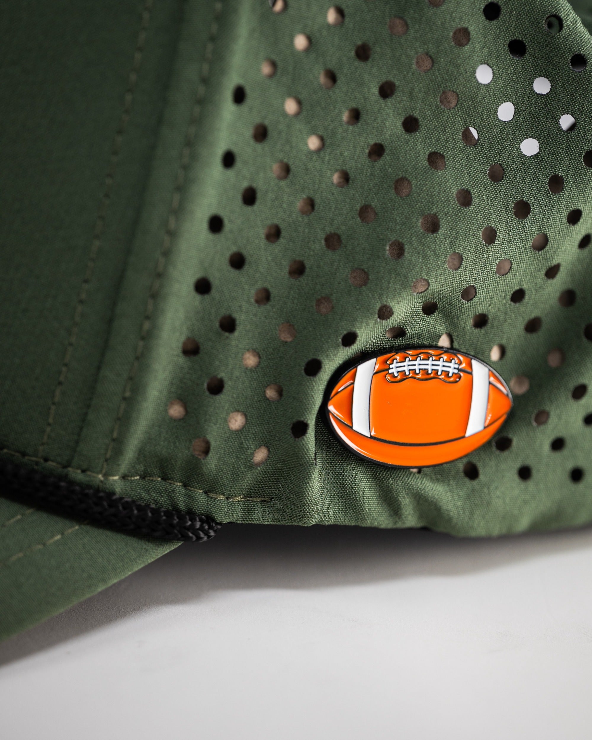 Olive perforated rope hat featuring a unique football emblem, designed for stylish golfers seeking comfort and breathability.