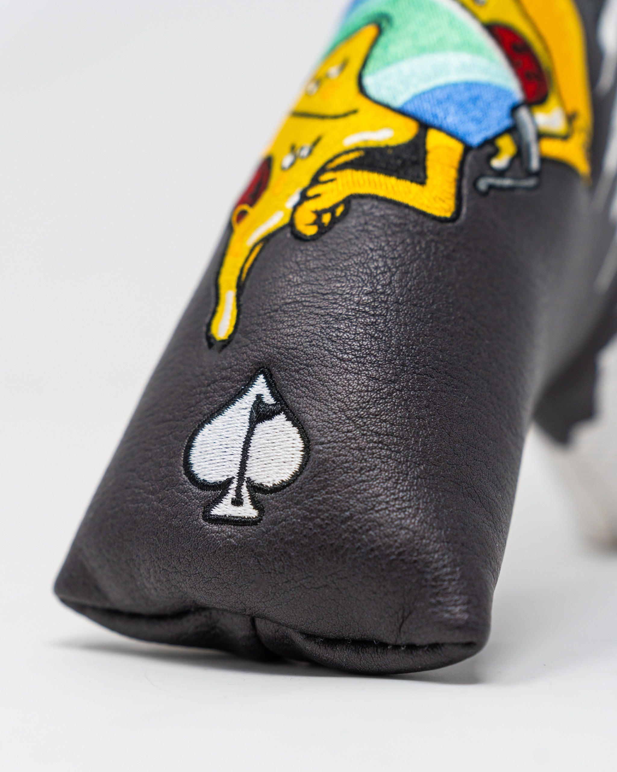 Bold black putter cover featuring colorful embroidered design and spade logo, perfect for stylish golfers.