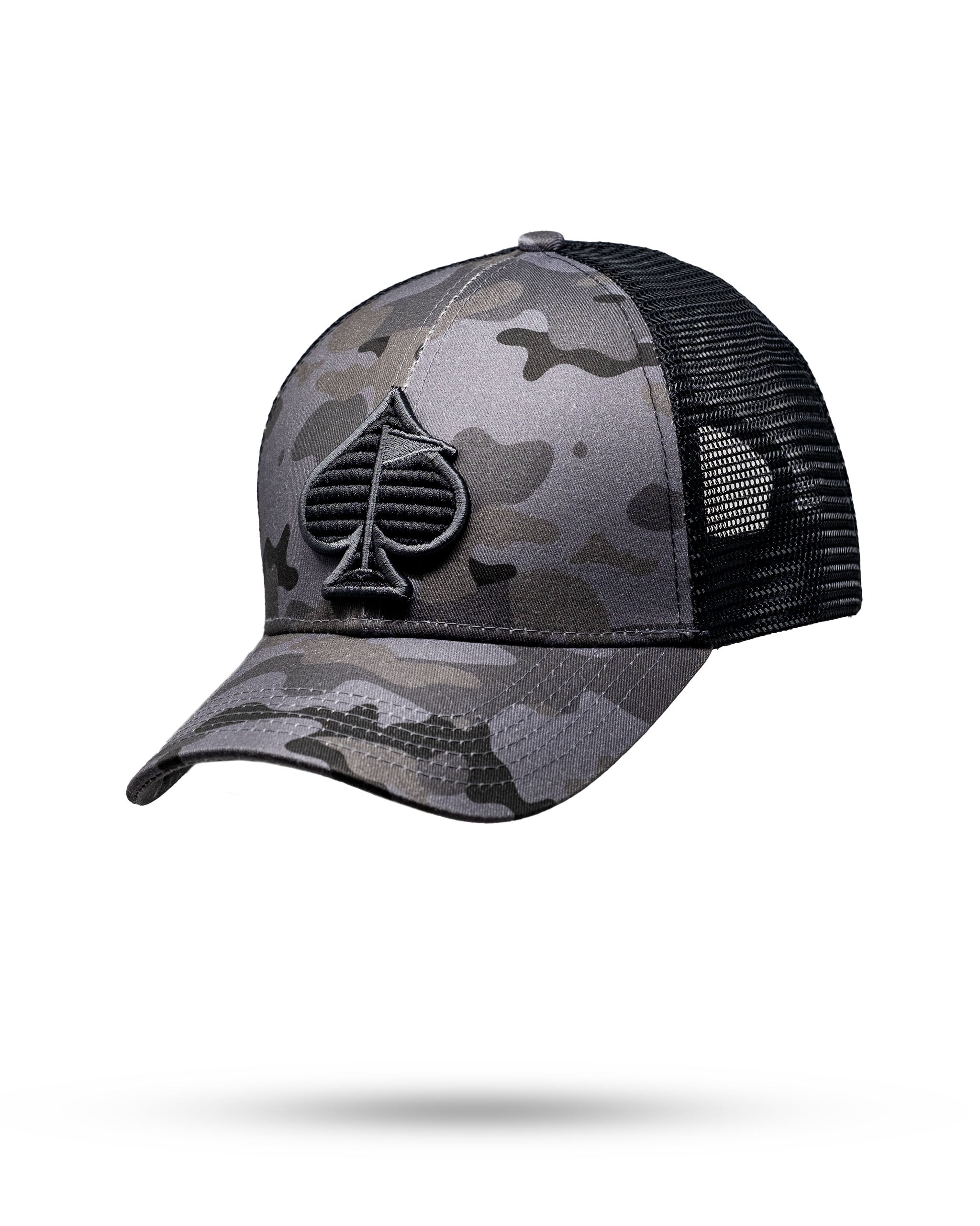 Urban camo trucker hat featuring a textured black spade logo, designed for bold golfers seeking unique style.