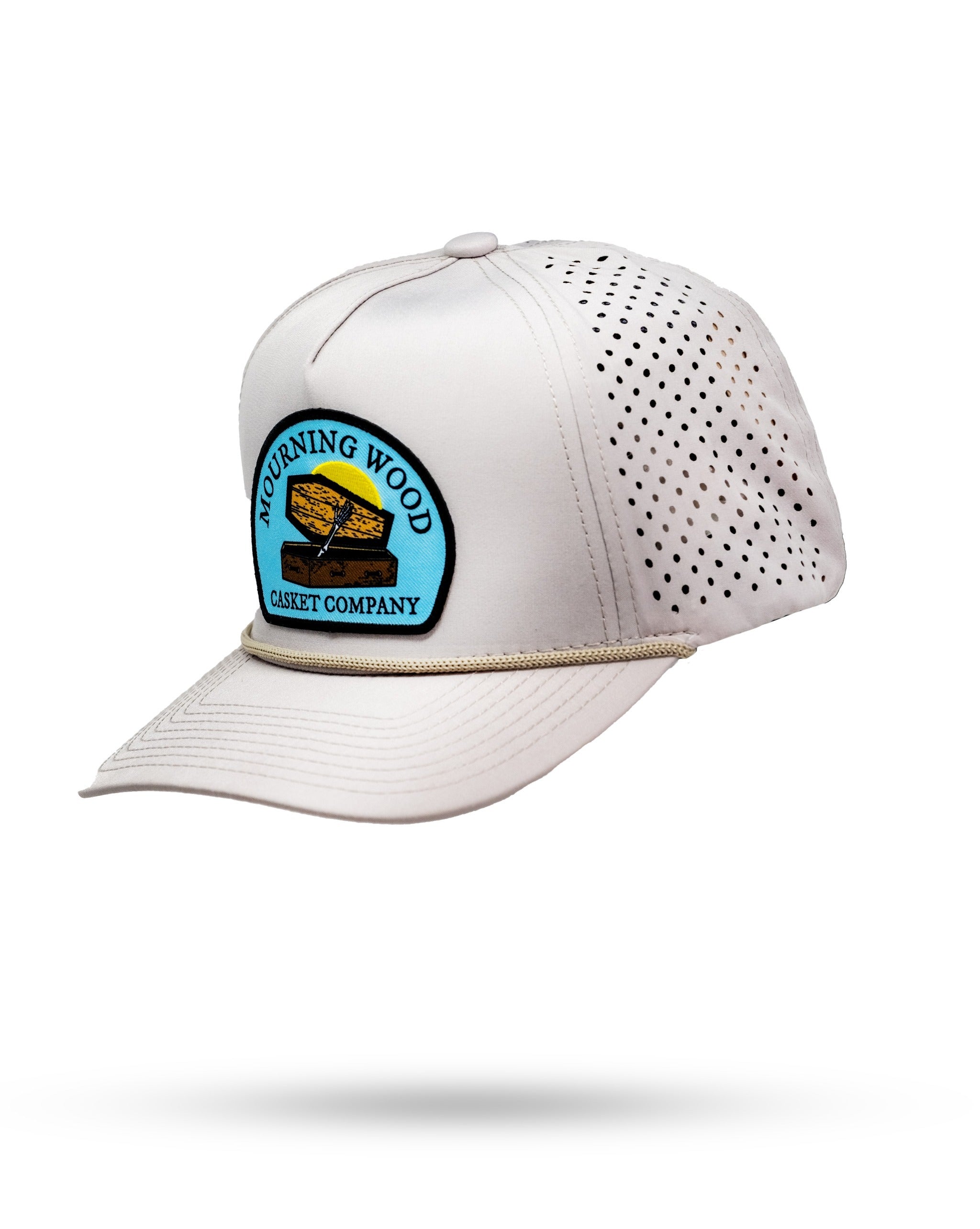 White golf cap with perforated sides, embroidered "Mourning Wood Casket Company" patch, and a curved brim.