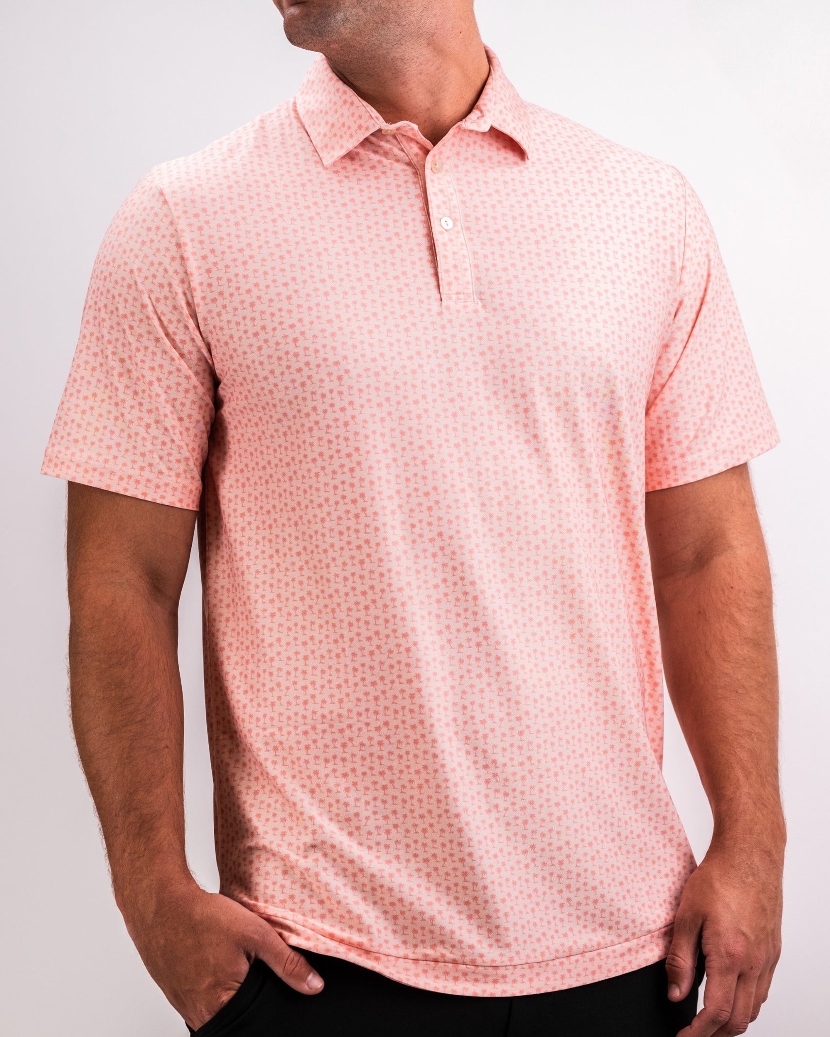 Men's coral polo shirt with a subtle palm pattern, designed for comfort and style on the golf course.