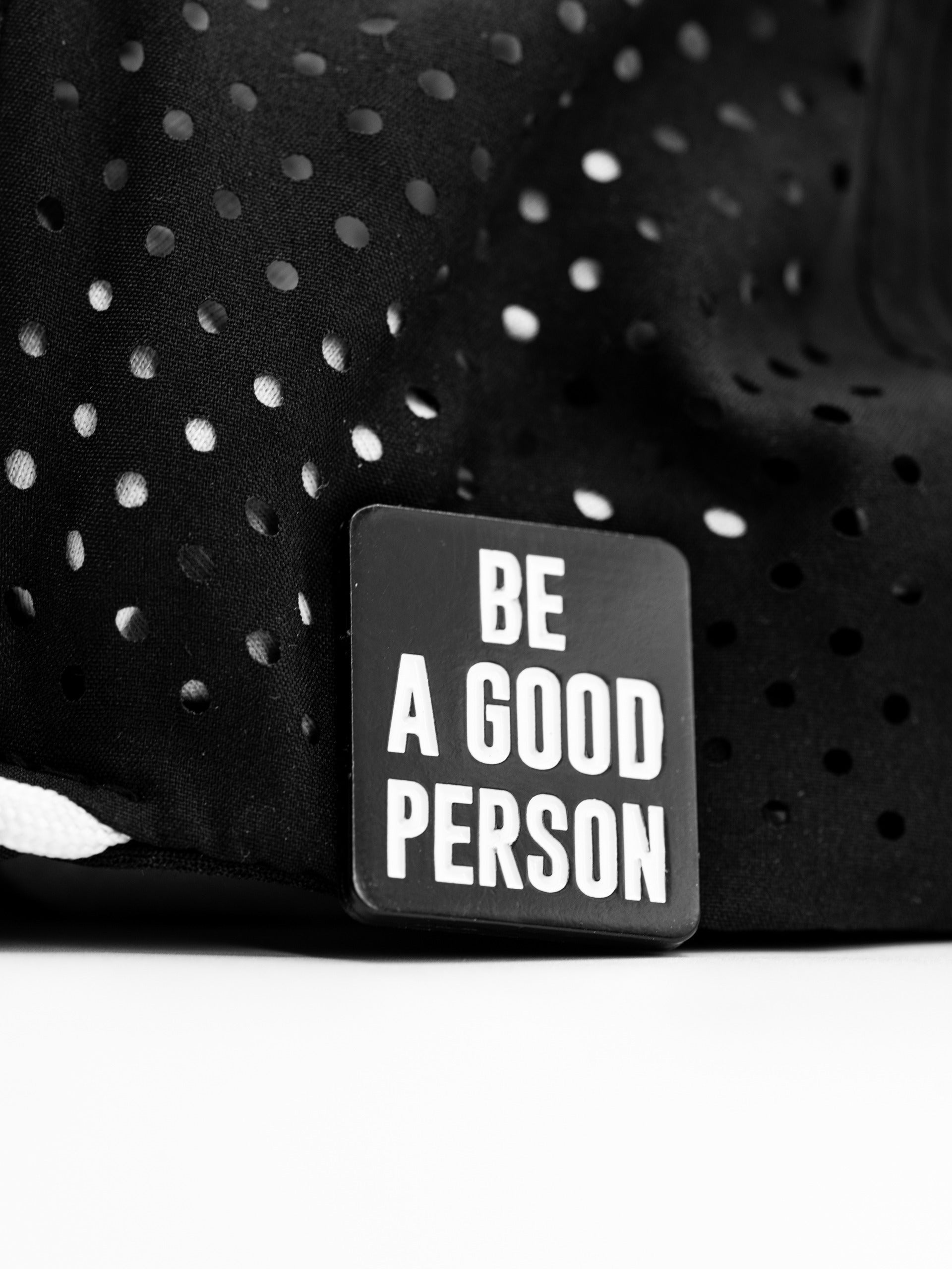 Black ball marker featuring the phrase "Be A Good Person" in bold white letters, designed for golfers.