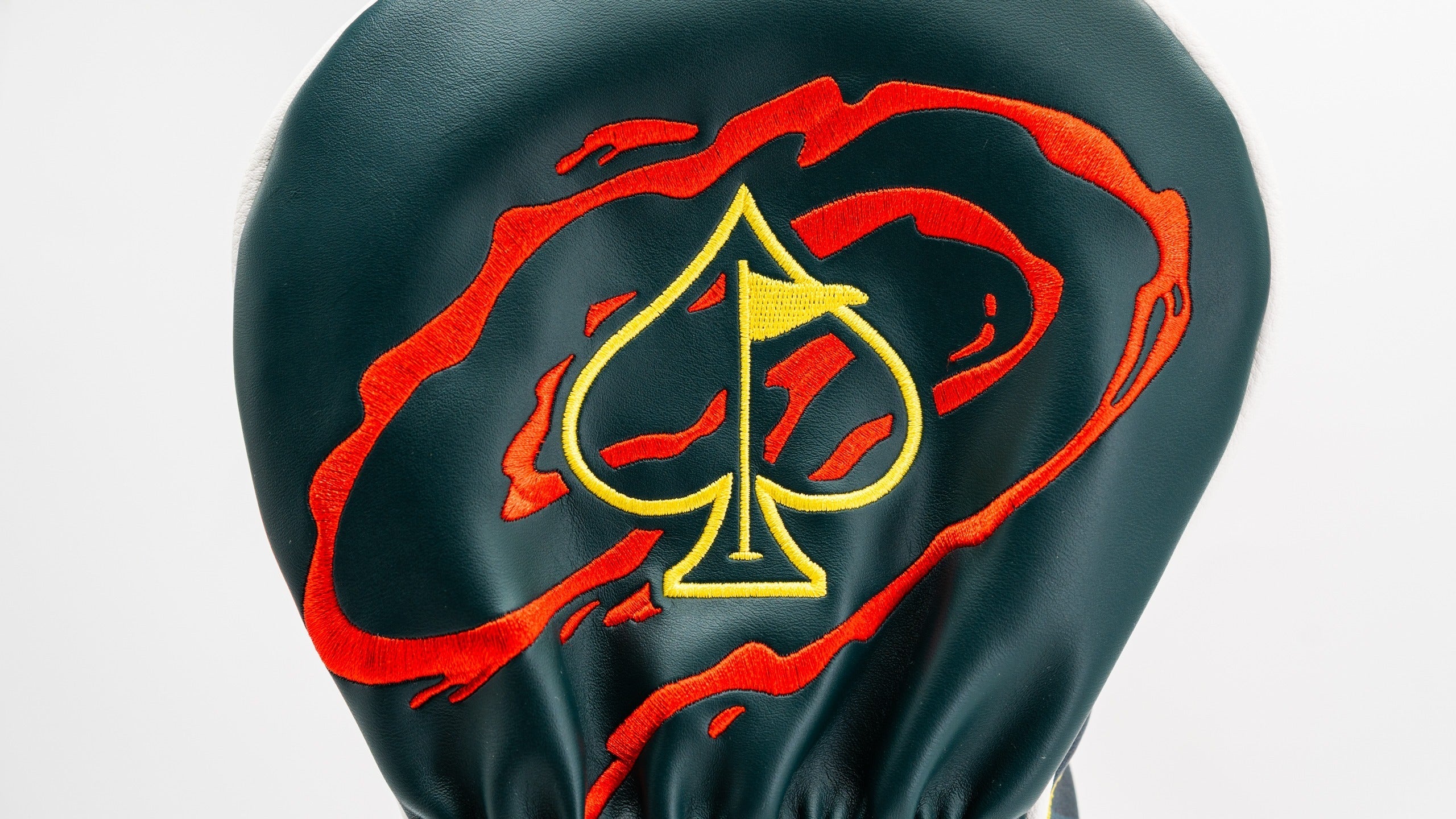 Bold driver cover featuring a striking spade logo with a fiery red and orange swirl design on a dark green background.