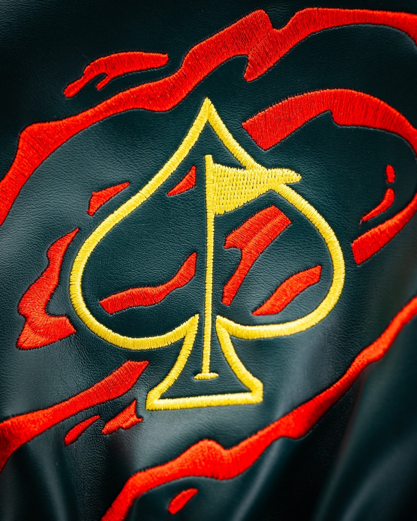 Bold driver cover featuring a vibrant red and black design with an embroidered yellow spade logo, perfect for standout golfers.