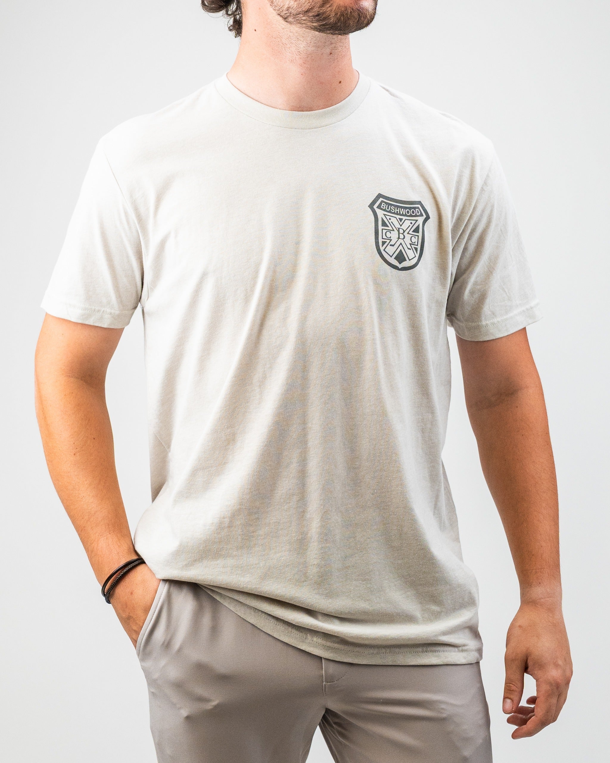 Men's Bushwood Crest 3.0 tee shirt in light gray featuring a chest logo, perfect for stylish golf outings.