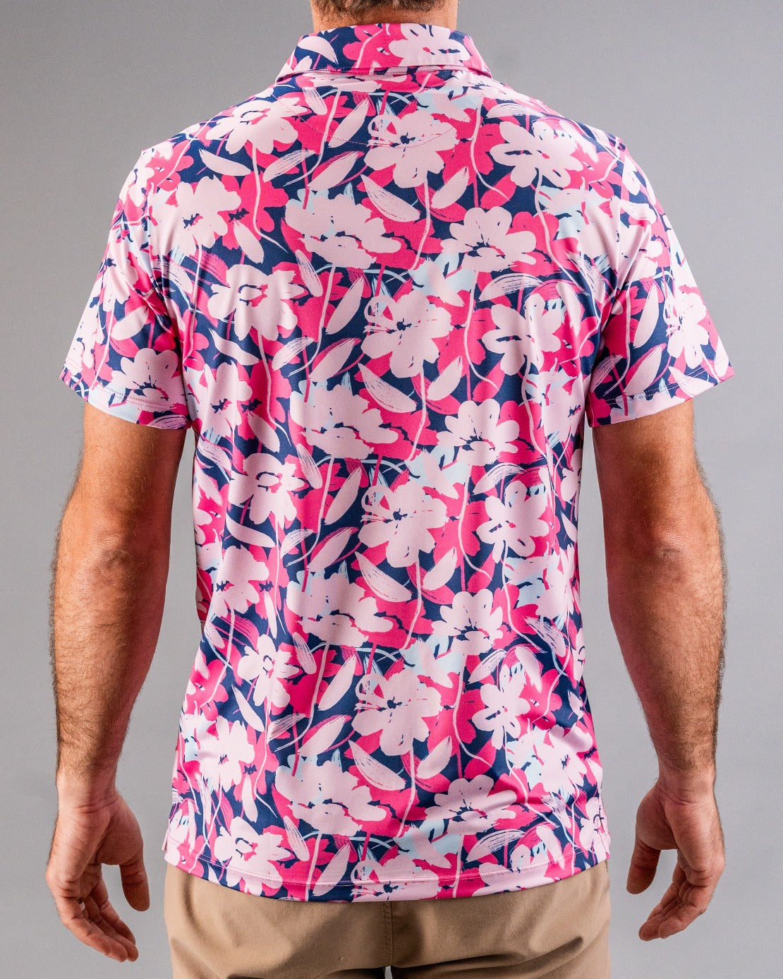 Bright pink, navy, and white floral golf shirt with a bold, colorful pattern for standout style on the course.