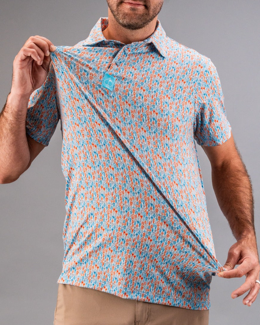 Man wearing a colorful, patterned golf polo with blue, orange, and white, showcasing bold, unique golf apparel for standin...