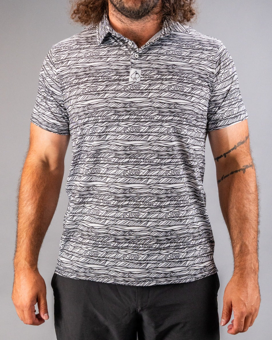 Men's Fragment Black golf polo featuring a bold abstract pattern, designed for stylish performance on the course.