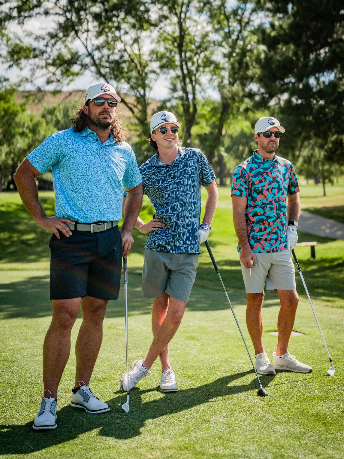 Three golfers on a course wearing colorful floral-patterned shirts and stylish hats, showcasing bold golf fashion.