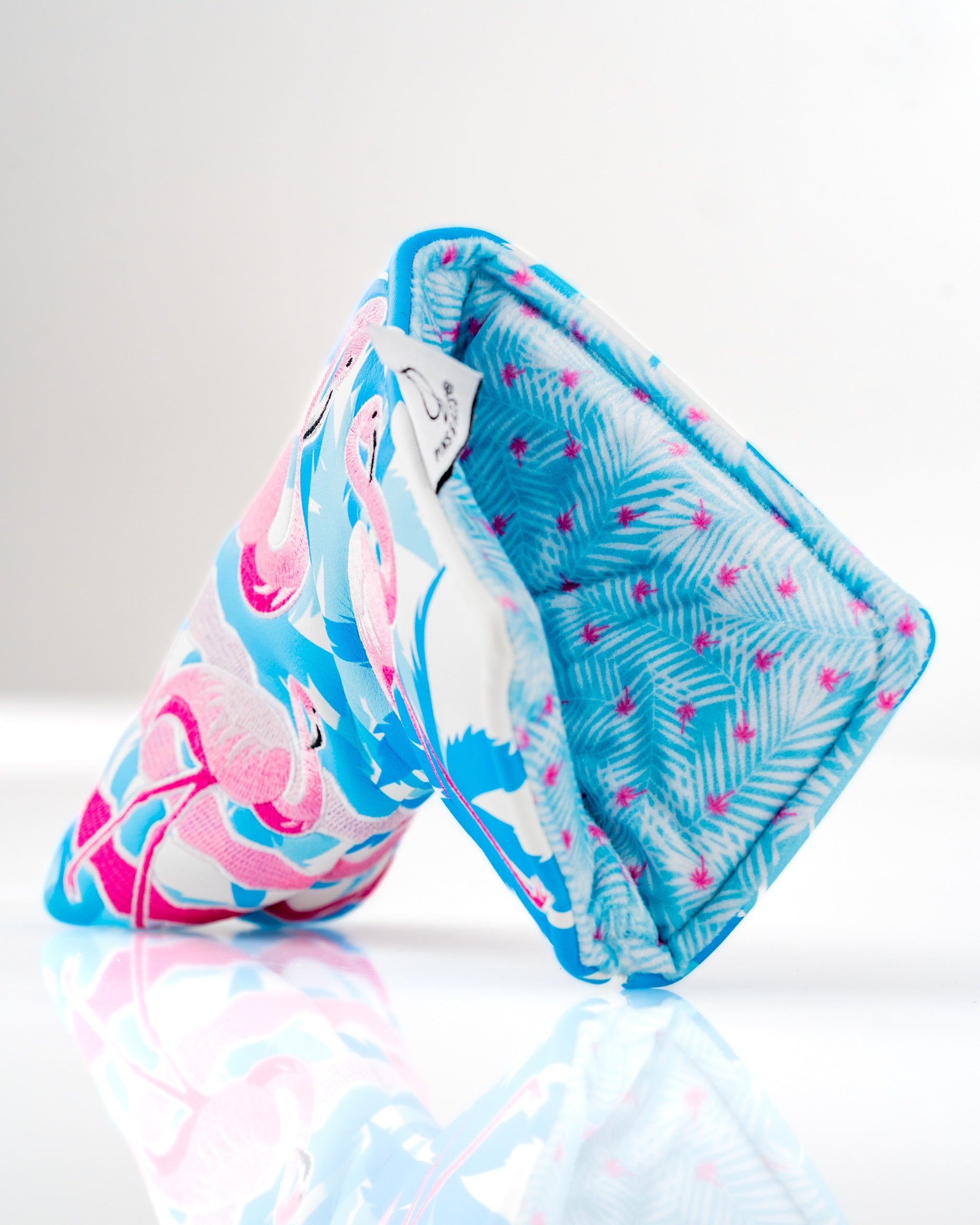 Bright flamingo-patterned blade putter cover with a vibrant blue background, designed for stylish golfers.