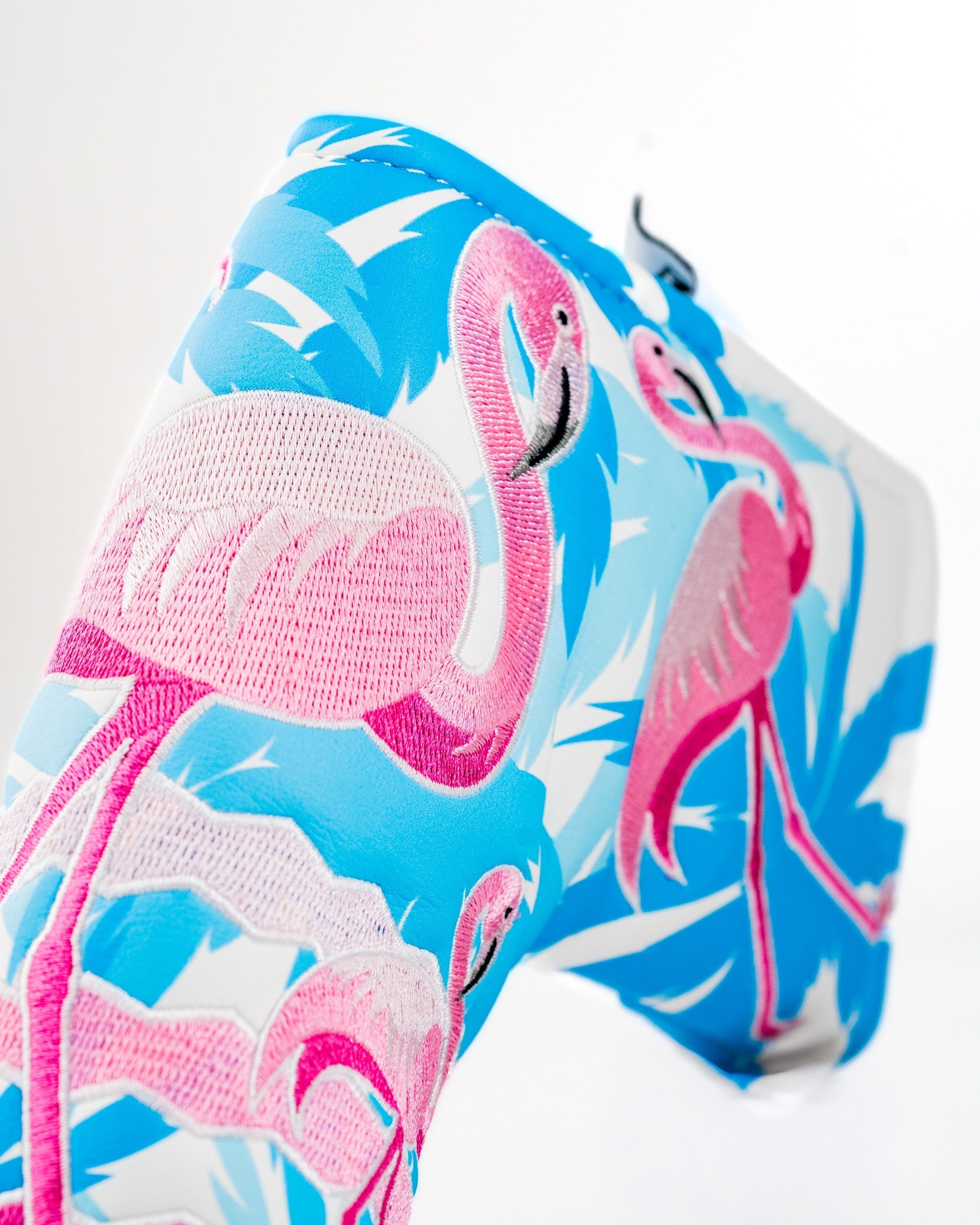Bright blue blade putter cover featuring vibrant pink flamingos and tropical foliage, perfect for stylish golfers.