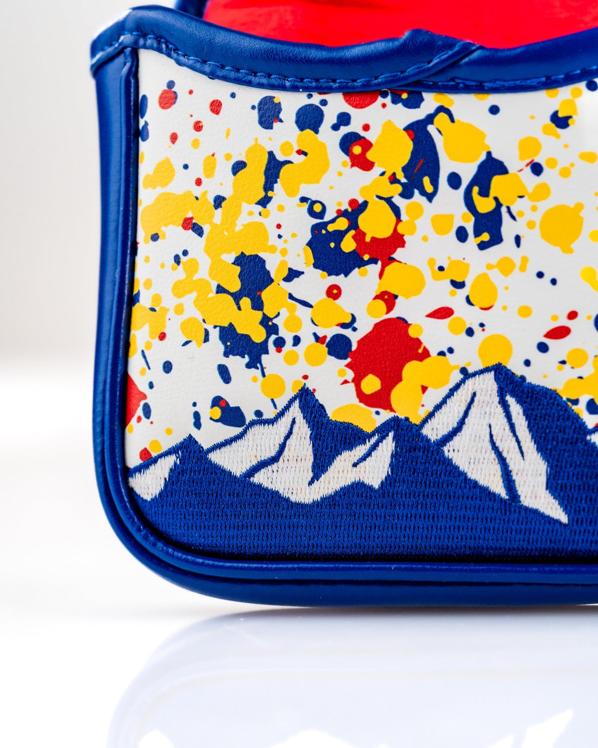 Bold mallet putter cover featuring a colorful splatter design with mountain silhouettes, perfect for standout golfers.