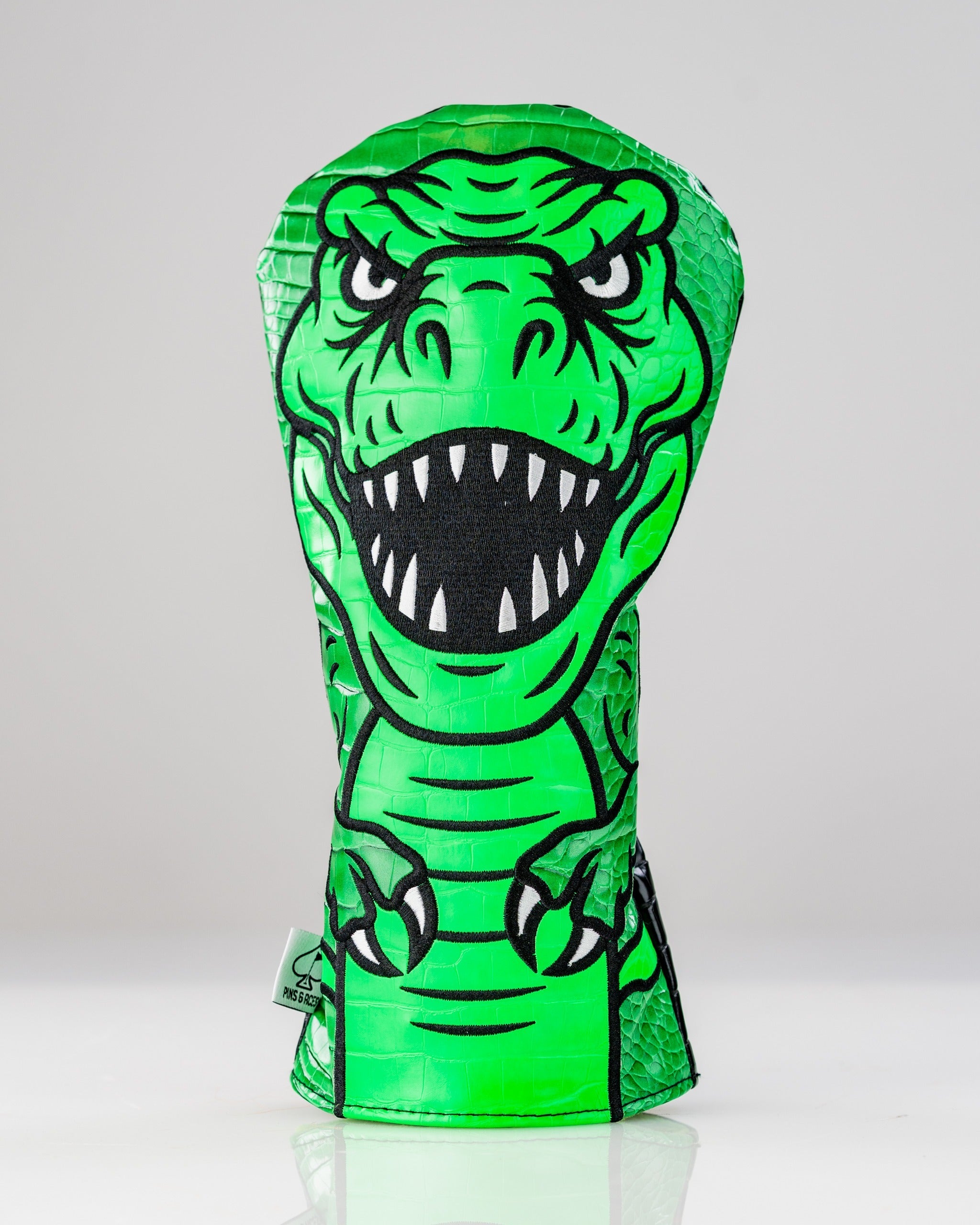 Bold T-Rex driver cover featuring a vibrant green dinosaur design with sharp teeth, perfect for standout golf style.
