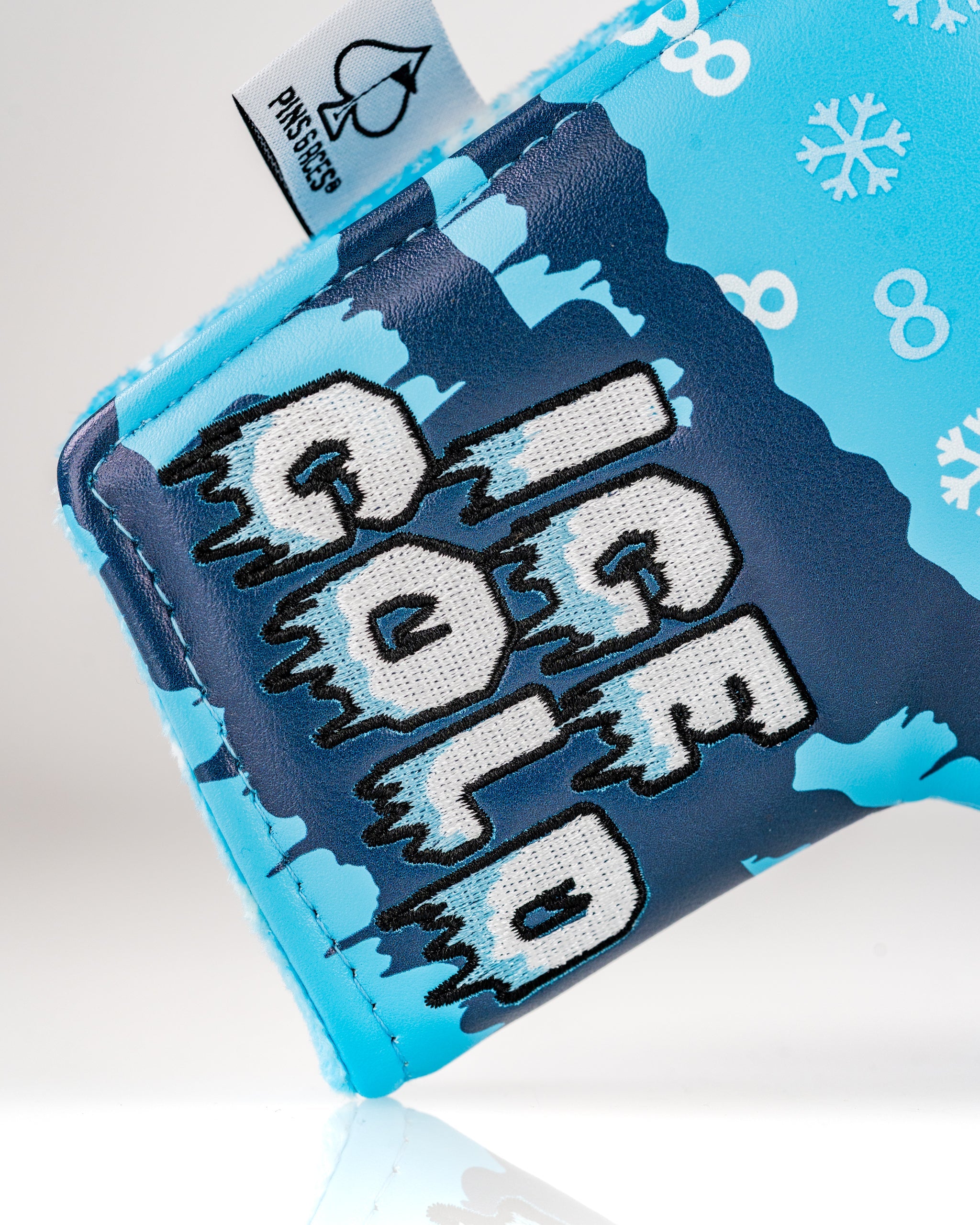 Snowman blade putter cover featuring a blue design with snowflakes and the phrase "Ice Cold" in bold lettering.