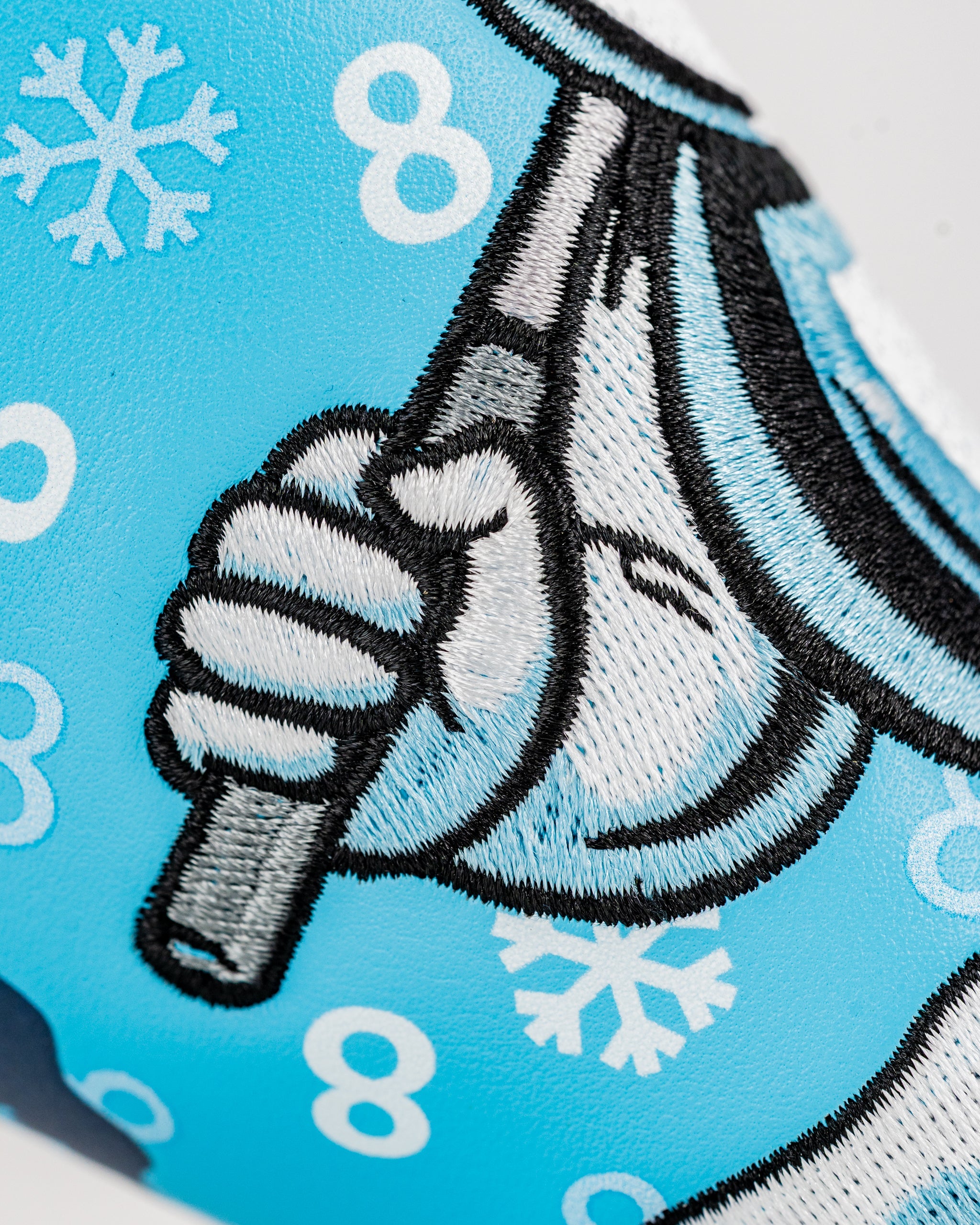 Snowman blade putter cover featuring a vibrant blue design with a snowman holding a golf club, perfect for winter golf.