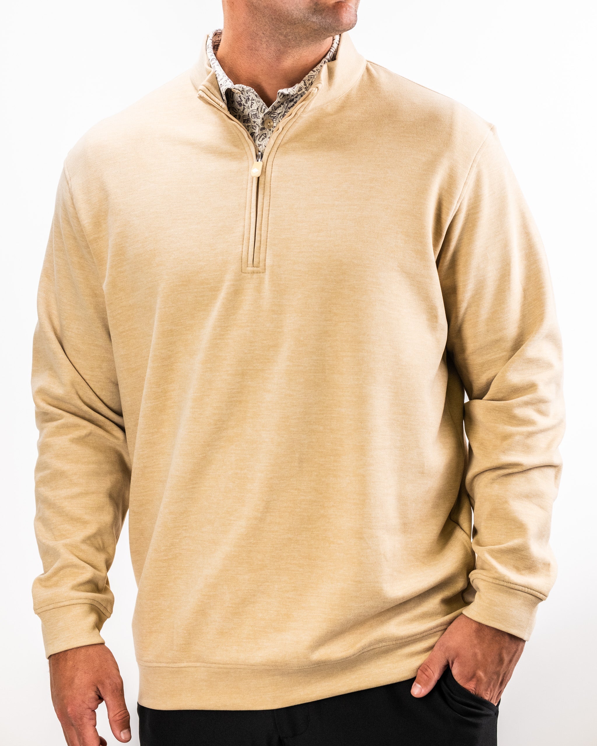 Men's beige Player Preferred™ Pullover in sand, featuring a quarter-zip collar and relaxed fit, layered over a patterned shirt.