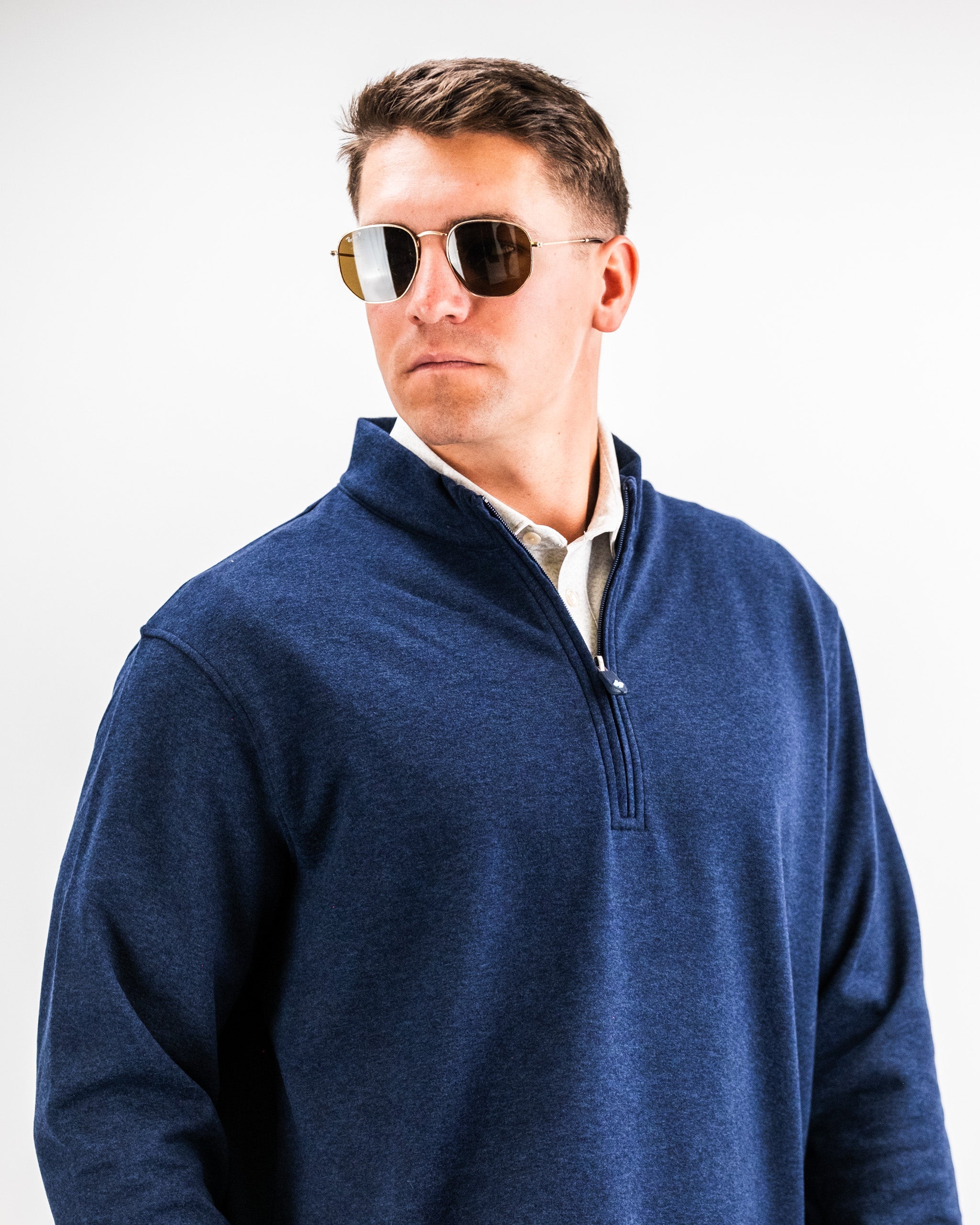 Man wearing a navy heathered Player Preferred™ Pullover with sunglasses, facing slightly to the side against a plain background.