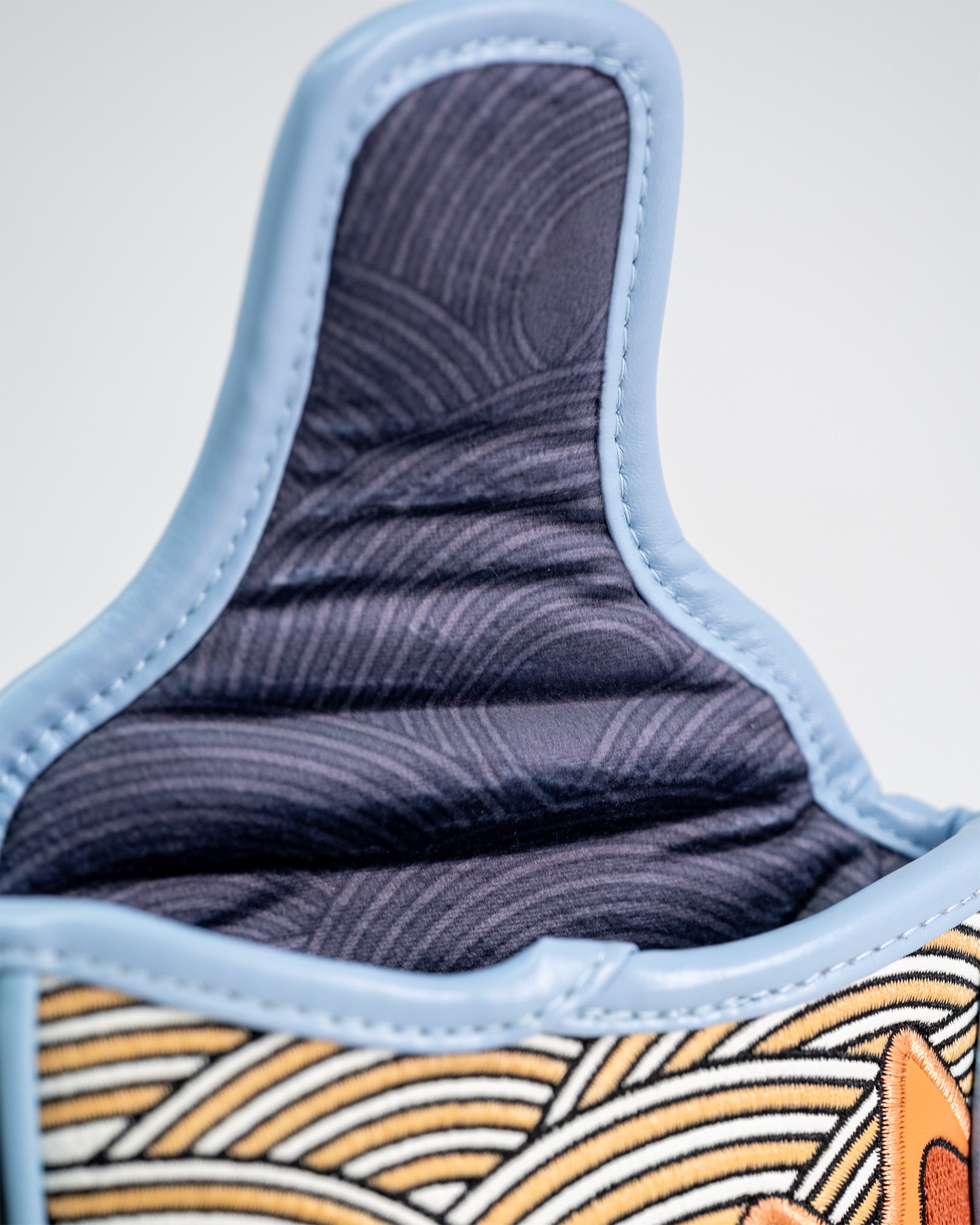 Close-up of a ramen-themed mallet putter cover with detailed stitching, fabric texture, and colorful embroidered design.