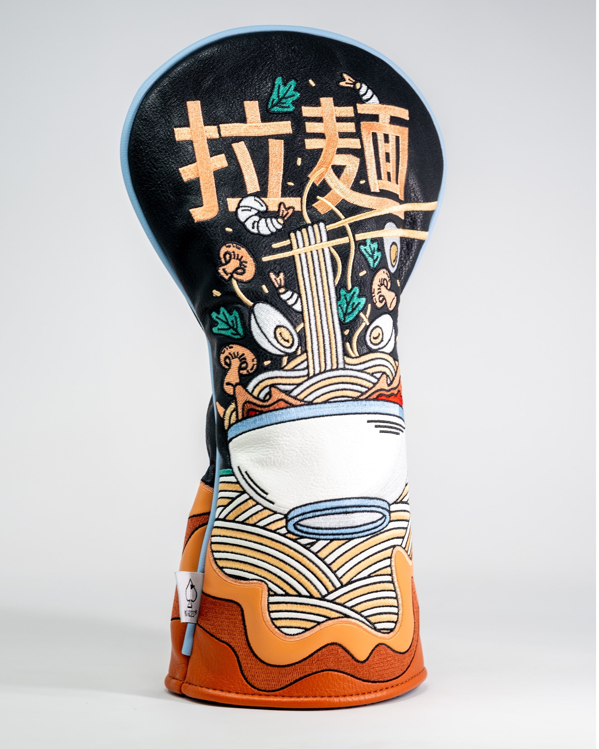 Golf driver cover featuring a colorful ramen bowl design with noodles, chopsticks, and vegetables on a black background.