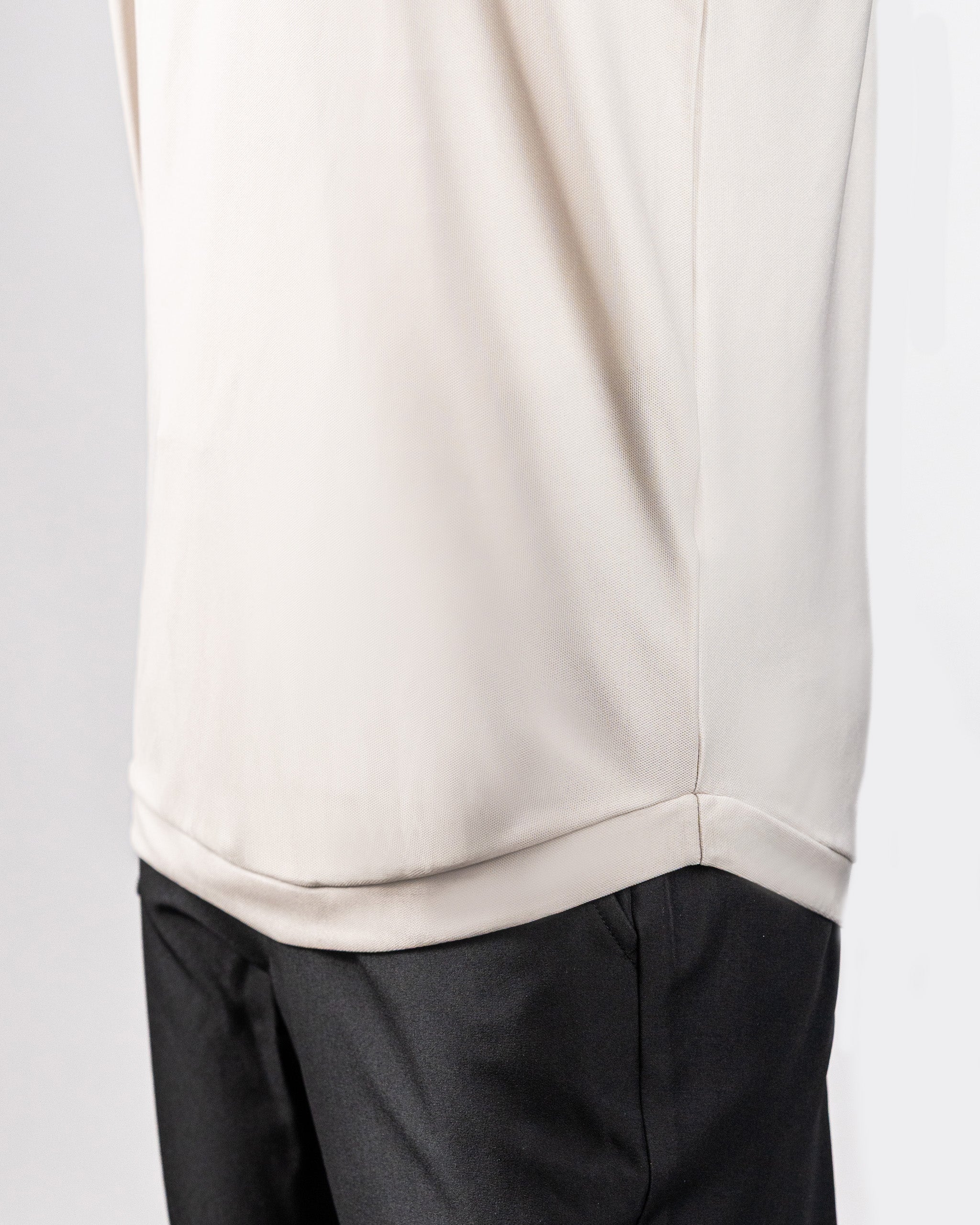 Close-up of a person wearing a light-colored Player Preferred™ Polo with Spade Fade Light pattern, paired with dark pants.