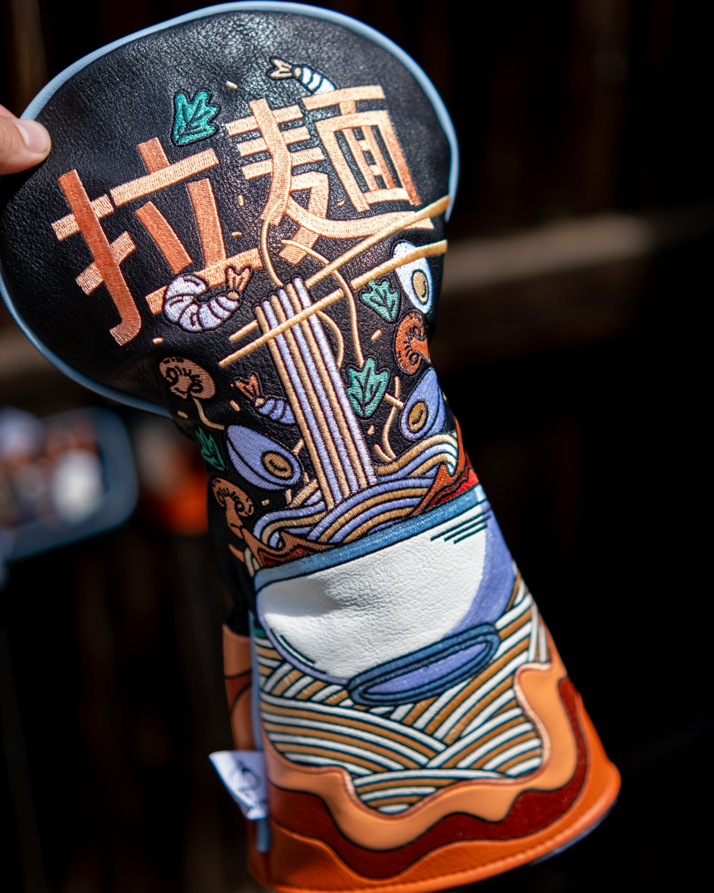 Colorful embroidered driver cover featuring a ramen bowl with noodles, chopsticks, vegetables, and Japanese characters.