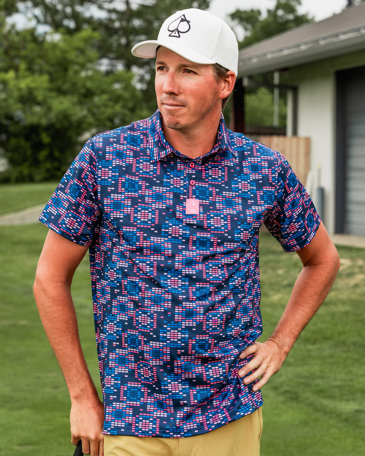 Bold Tetrafloral Dark golf shirt featuring a vibrant geometric pattern, worn by a golfer on the course.