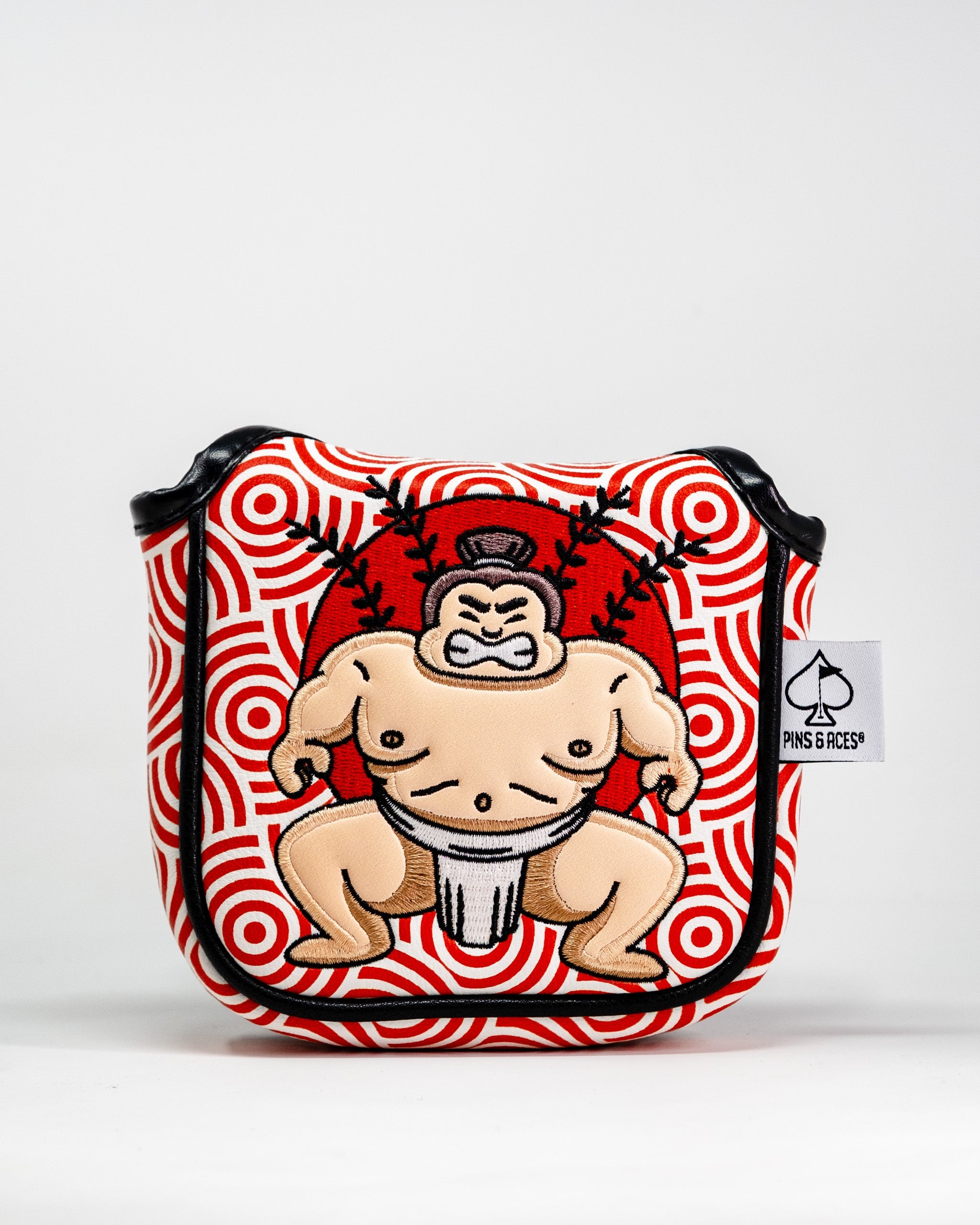Sumo wrestler embroidered patch on a red and white patterned golf mallet putter cover with black trim and a Pins and Aces tag.