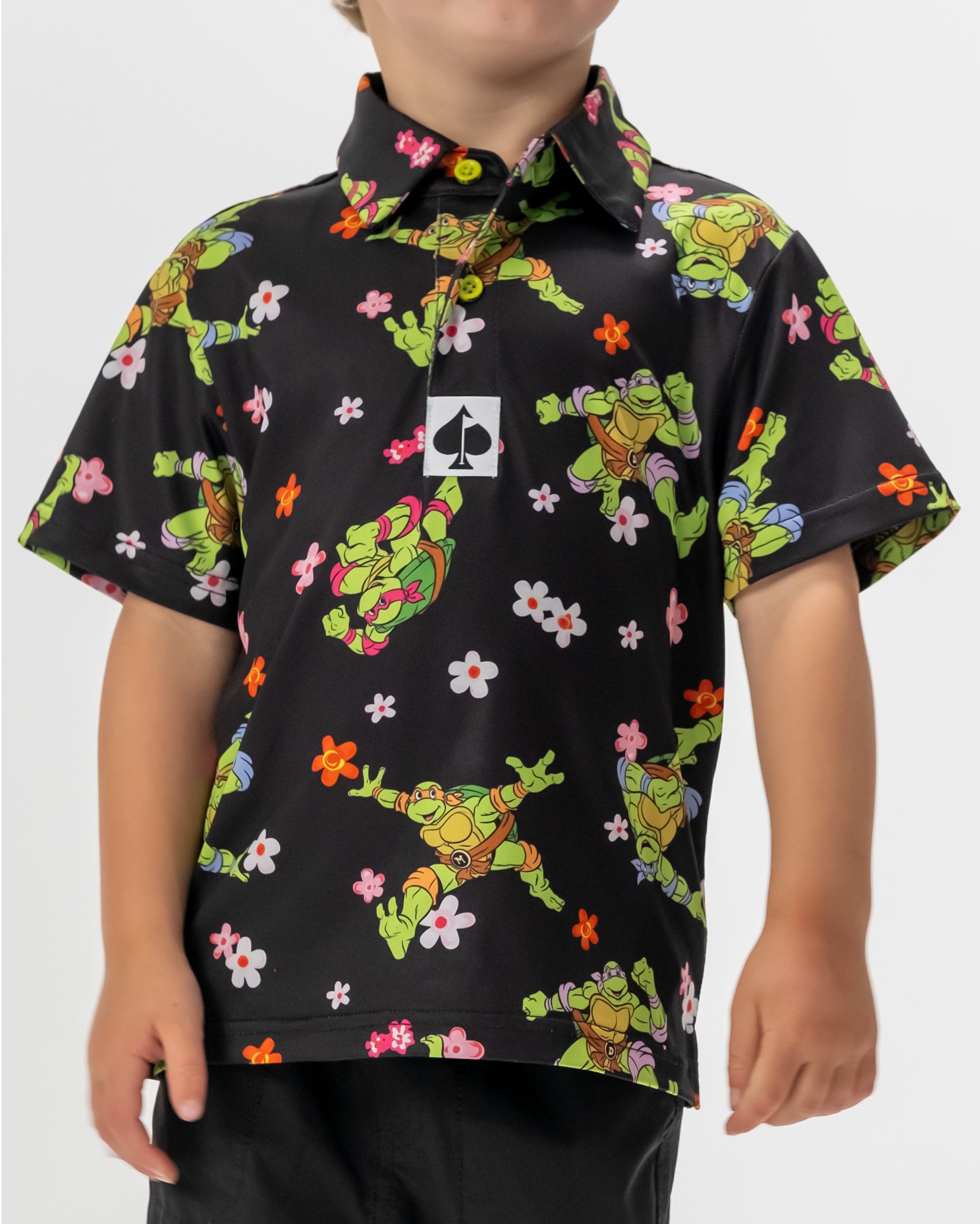 TMNT Youth Turtle Flower Power polo shirt featuring colorful turtle and floral designs.