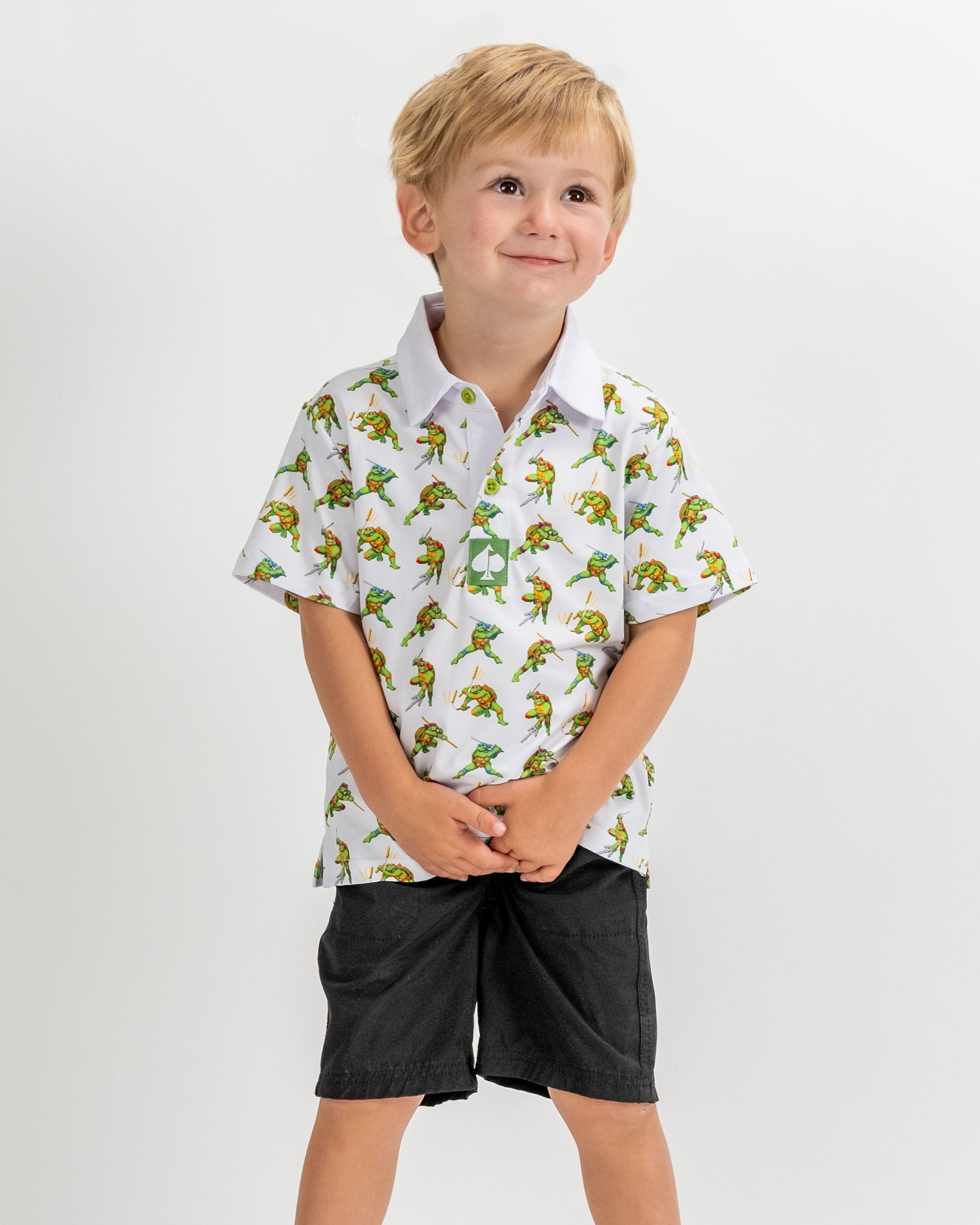 TMNT Youth Cowabunga Classic 8-Bit polo featuring iconic Teenage Mutant Ninja Turtles graphics in vibrant colors.