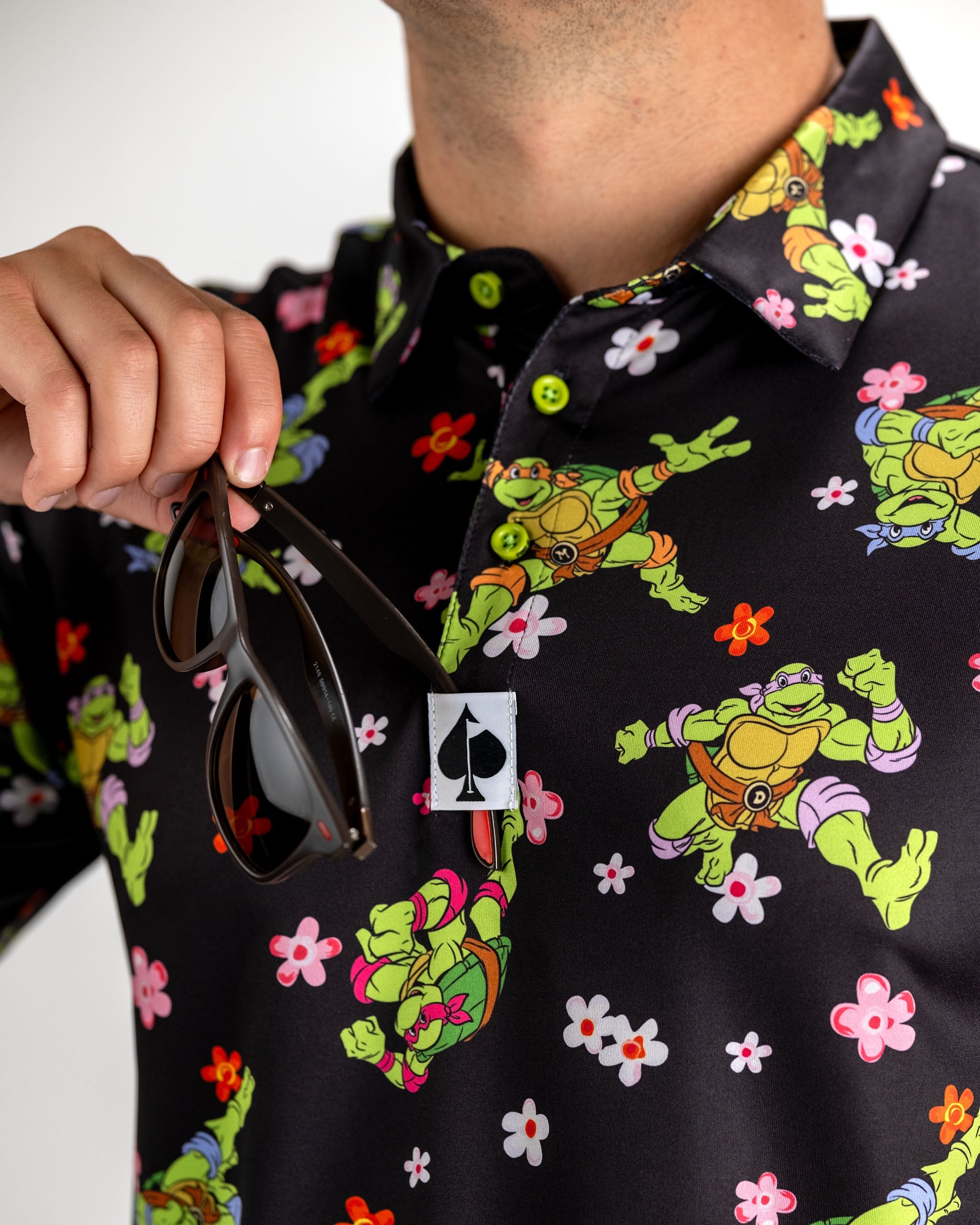TMNT Turtle Flower Power polo shirt featuring colorful graphic design.