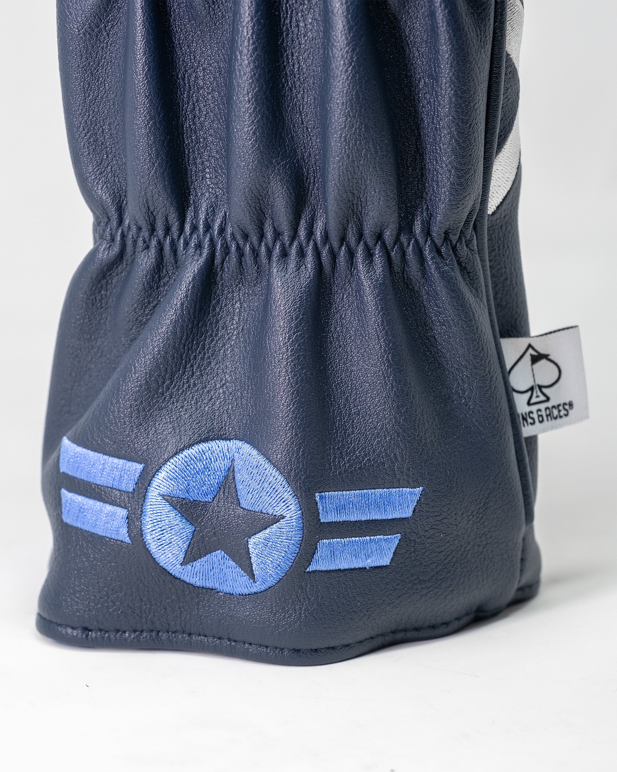 Top Gun Maverick golf driver headcover in navy blue faux leather with embroidered star and wing design, elastic opening for secure fit.