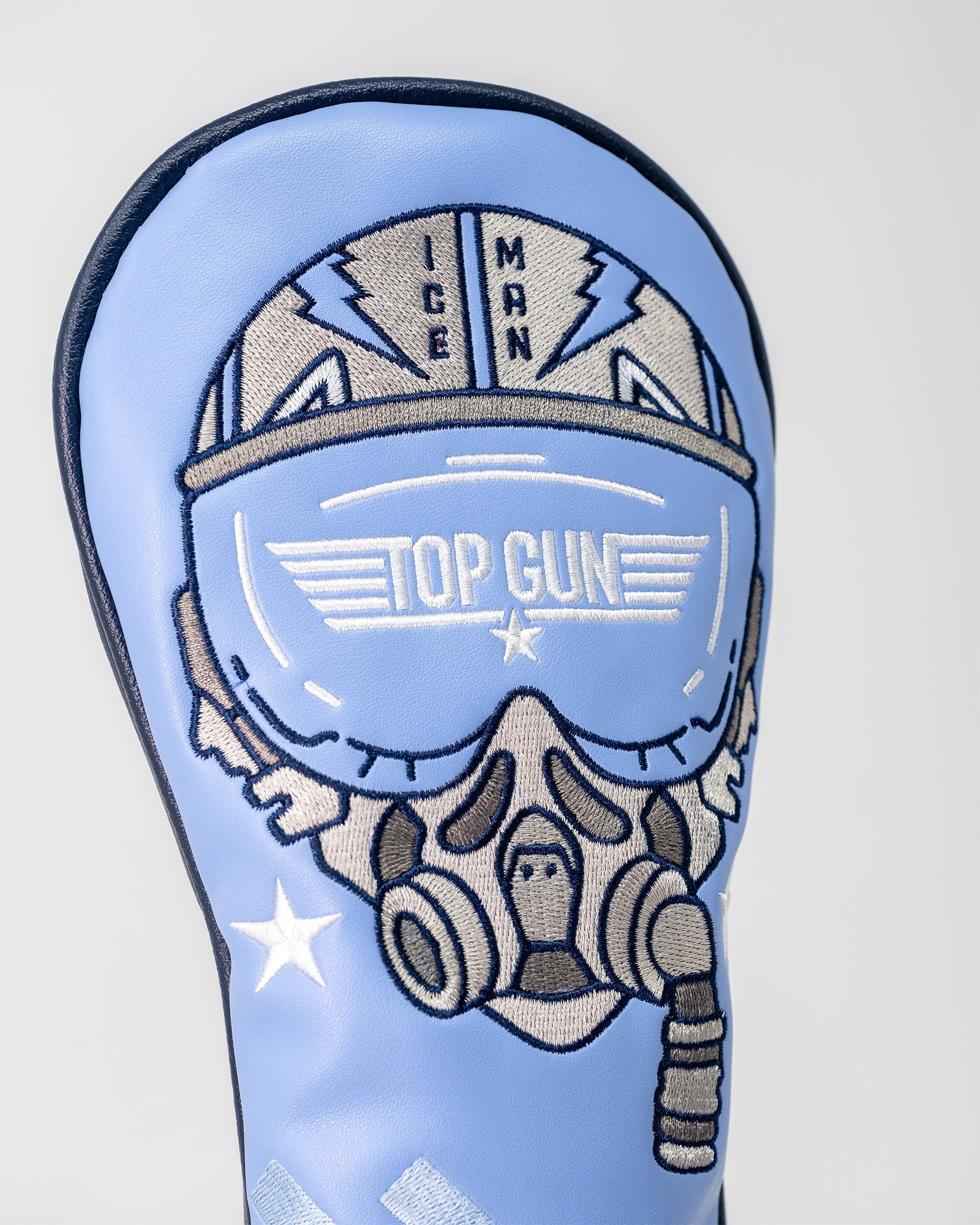 Embroidered Top Gun Ice Man helmet with goggles and stars on a light blue golf club headcover.