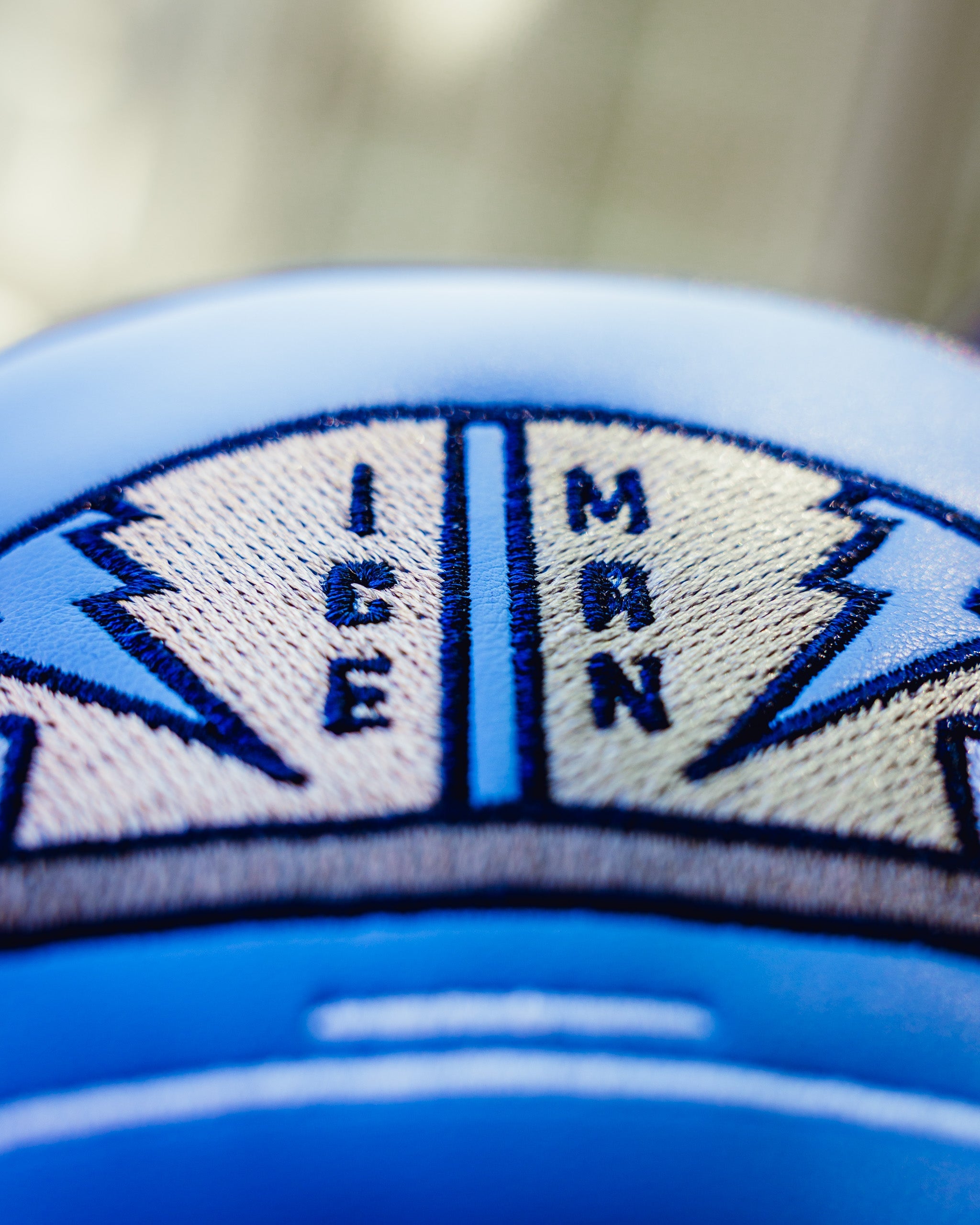Close-up of the Top Gun Ice Man fairway headcover showing embroidered navy blue and beige patch with compass design and "Ice Man" text.