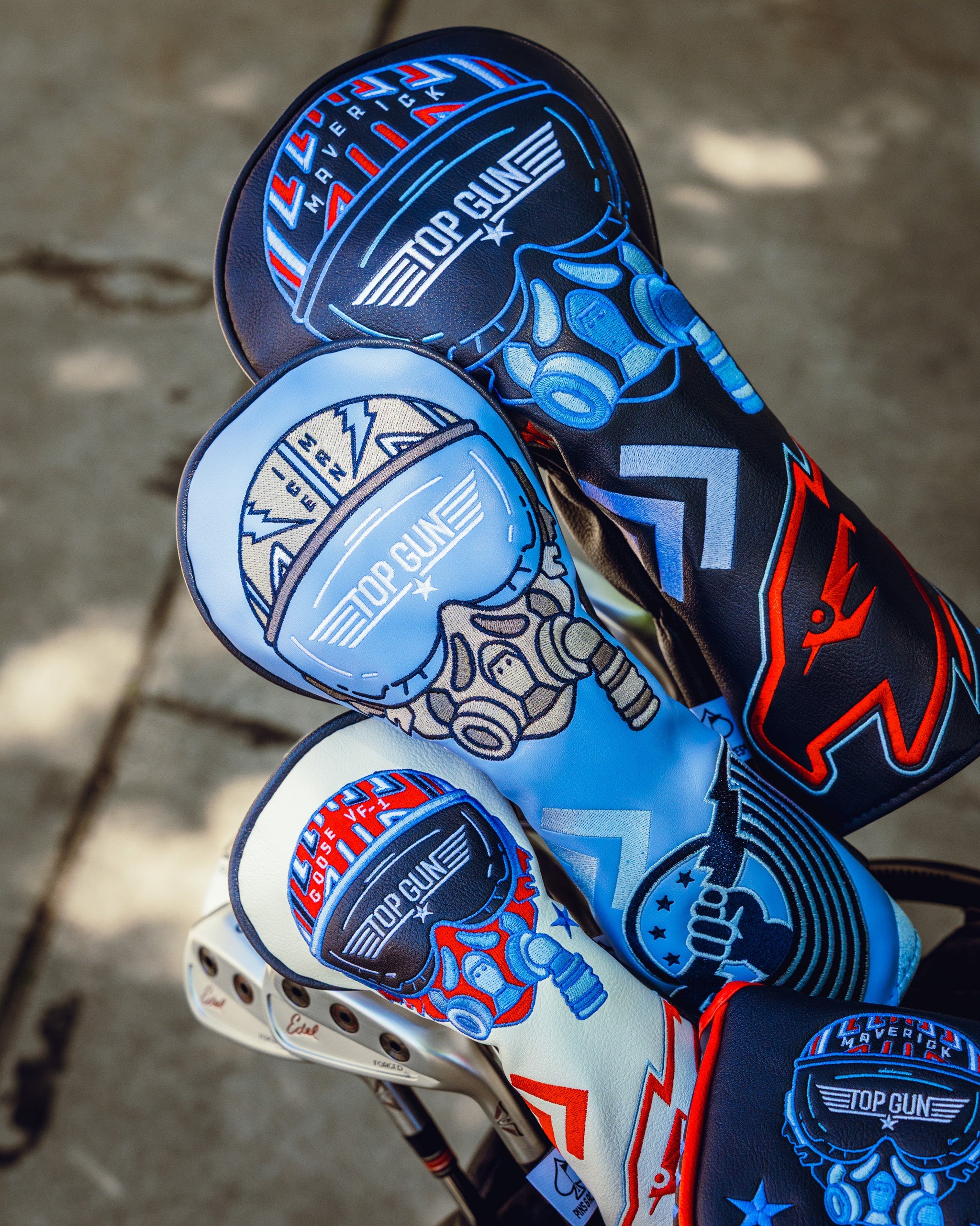 Three Top Gun Maverick-themed golf driver headcovers featuring aviation and fighter pilot designs in black, white, and blue colors.