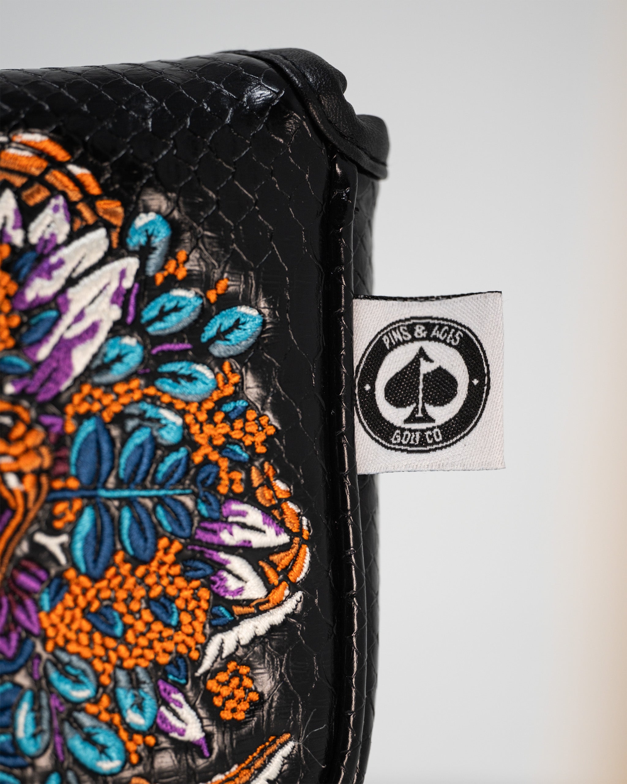 Alt text: Venom golf mallet putter cover with a black and red design featuring the Venom logo and spider motifs.