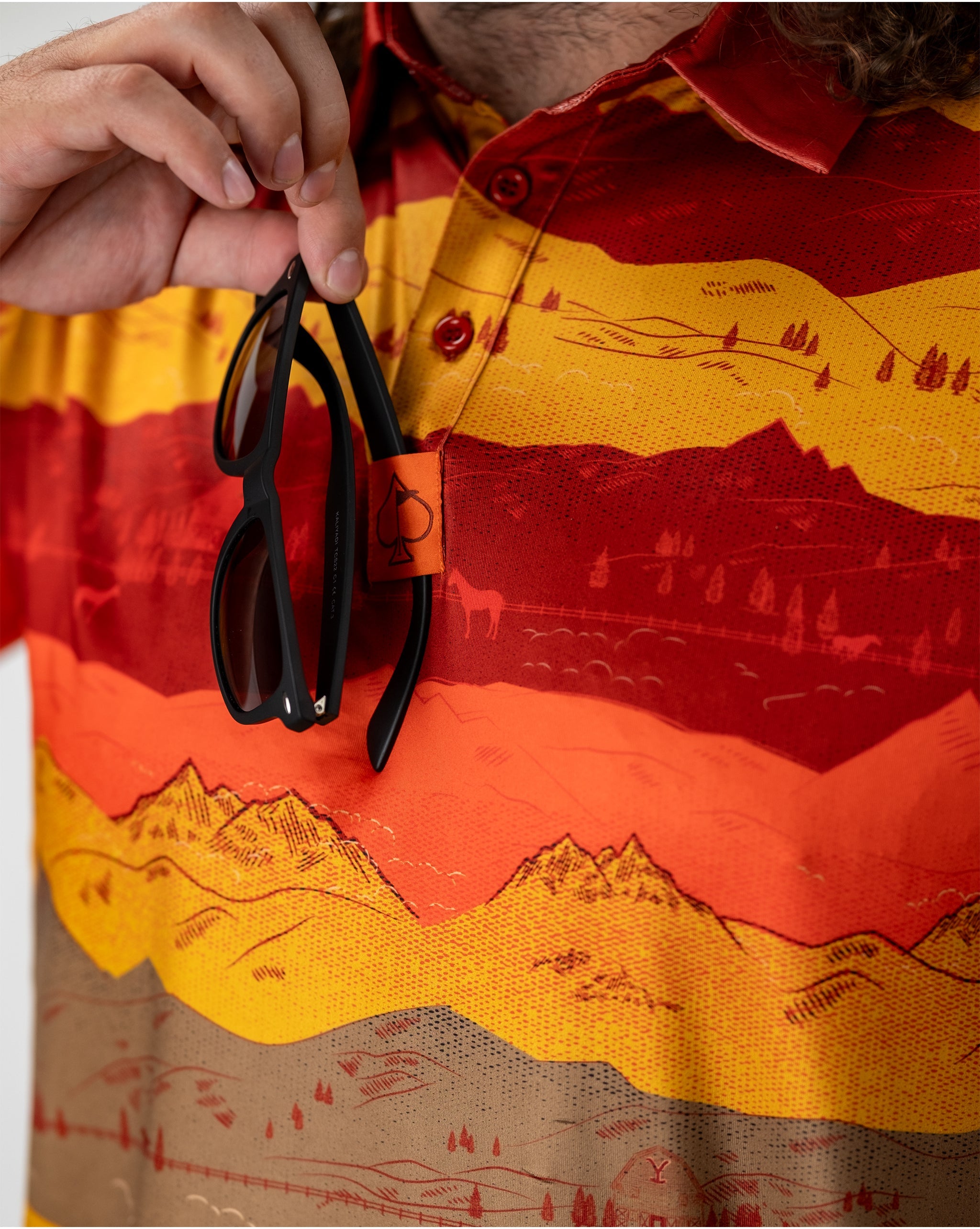 Sunset over Yellowstone National Park, highlighting vibrant orange and pink skies with silhouettes of trees and mountains.