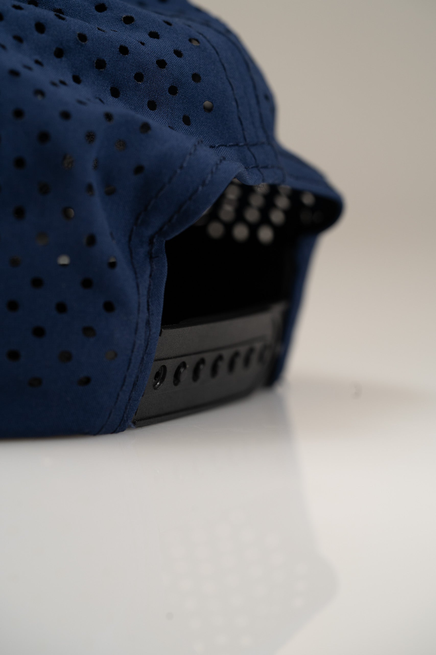 Navy perforated rope hat from Zynbabwe Country Club, featuring a stylish design and adjustable strap for comfort.