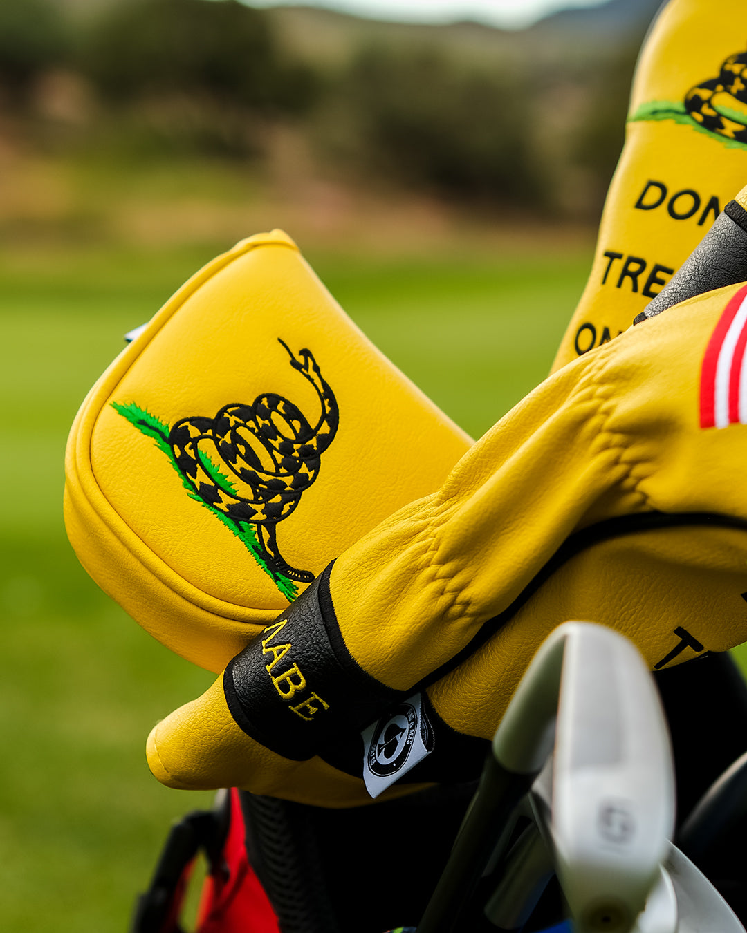Bold yellow mallet putter cover featuring the "Don't Tread on Me" design, perfect for golfers wanting to stand out.