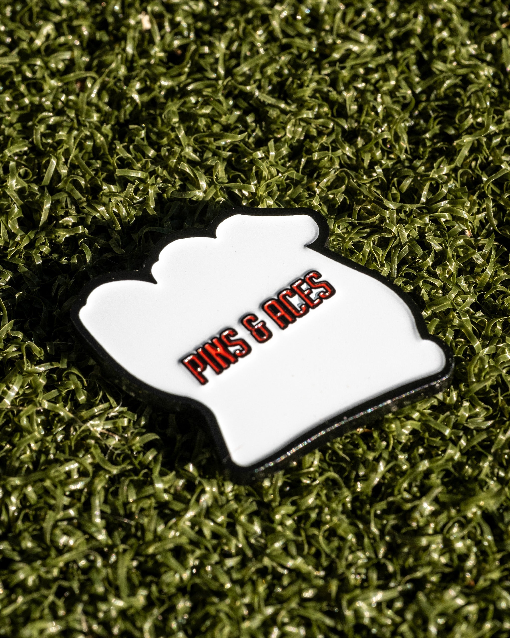 Bold golf ball marker featuring the Pins and Aces logo, designed for golfers who want to stand out on the course.