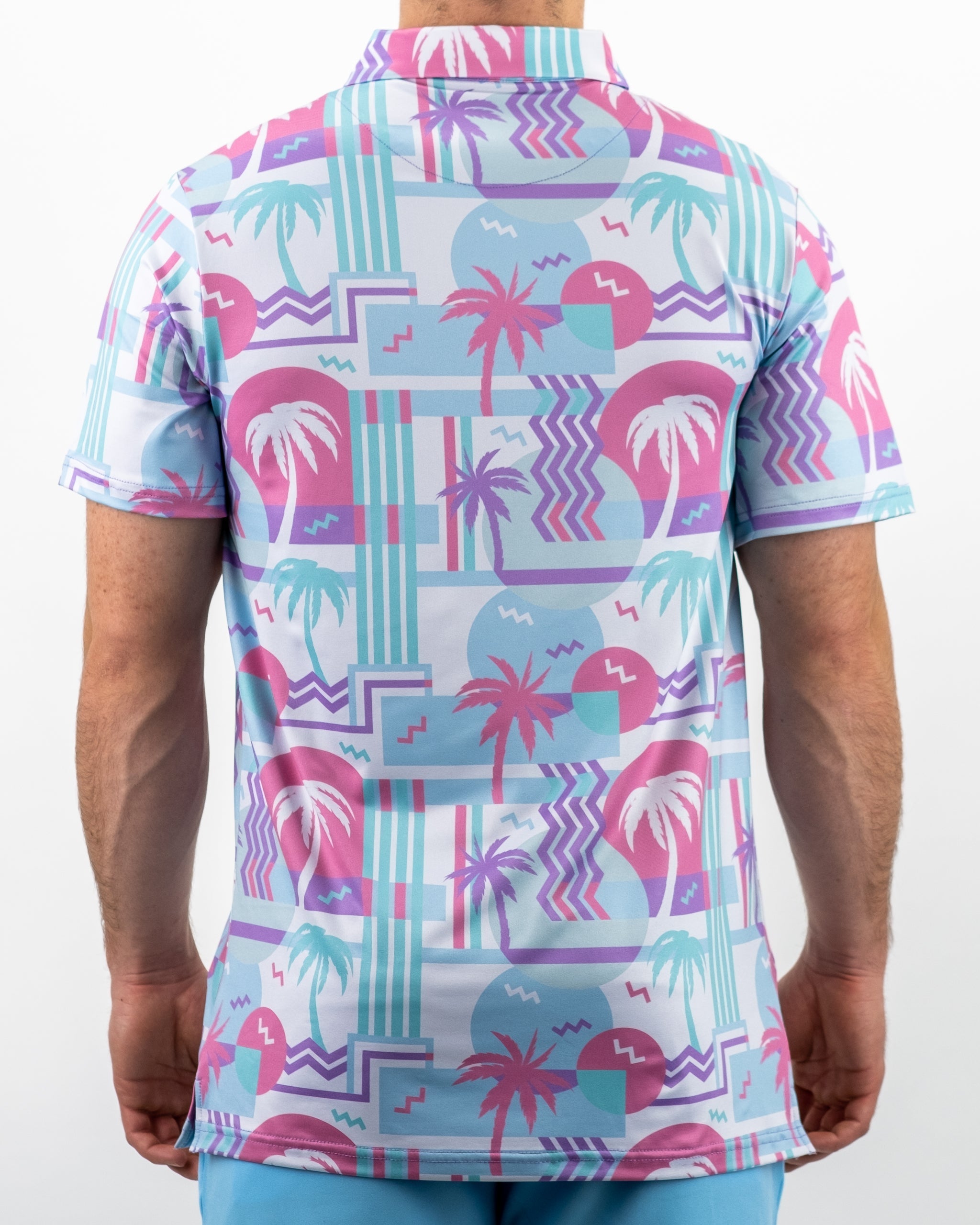 Men's golf shirt featuring a vibrant beach-themed pattern with palm trees and geometric shapes in pastel colors.