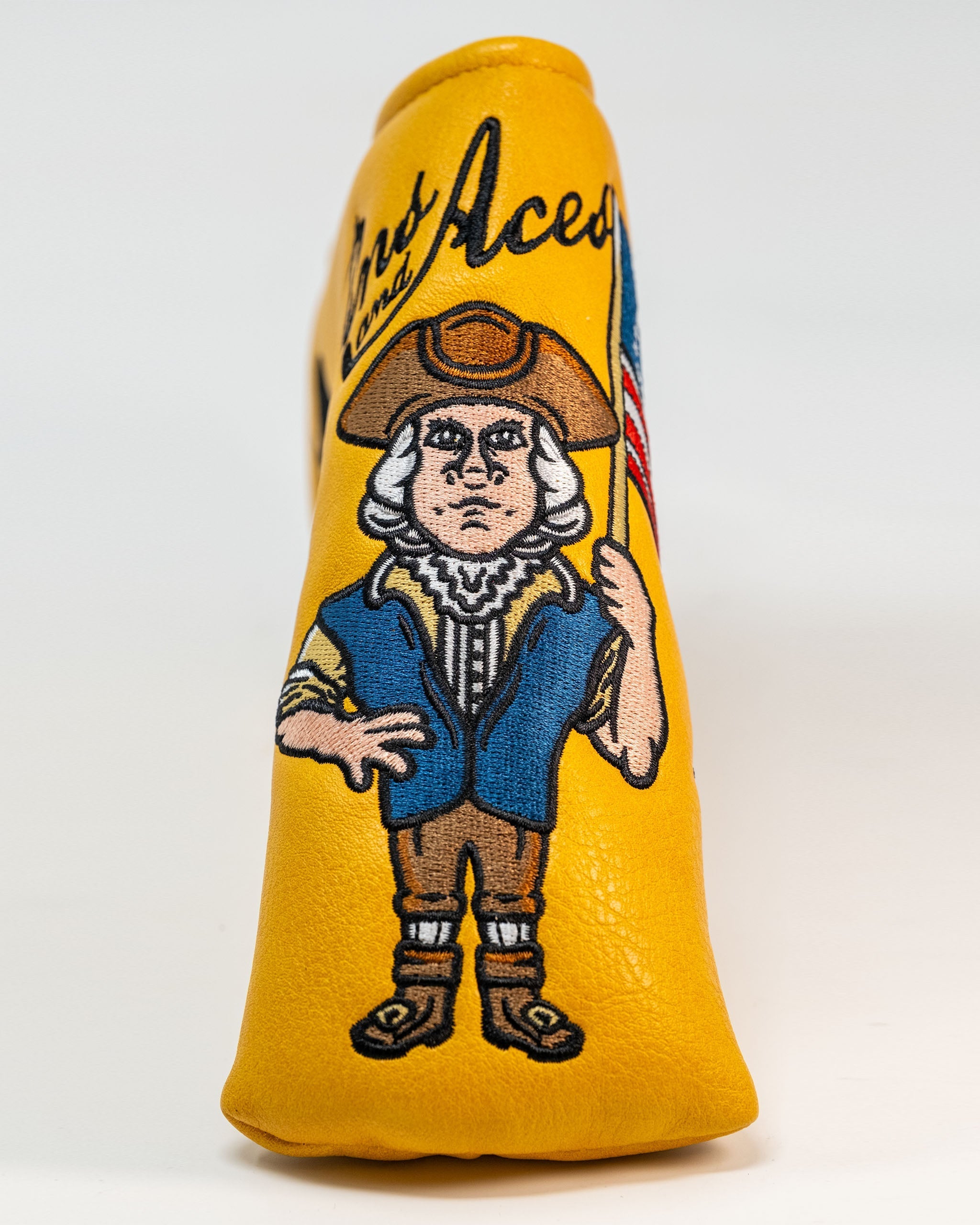 Patriot Blade Putter Cover featuring a colorful illustration of a historical figure holding an American flag on a yellow background.
