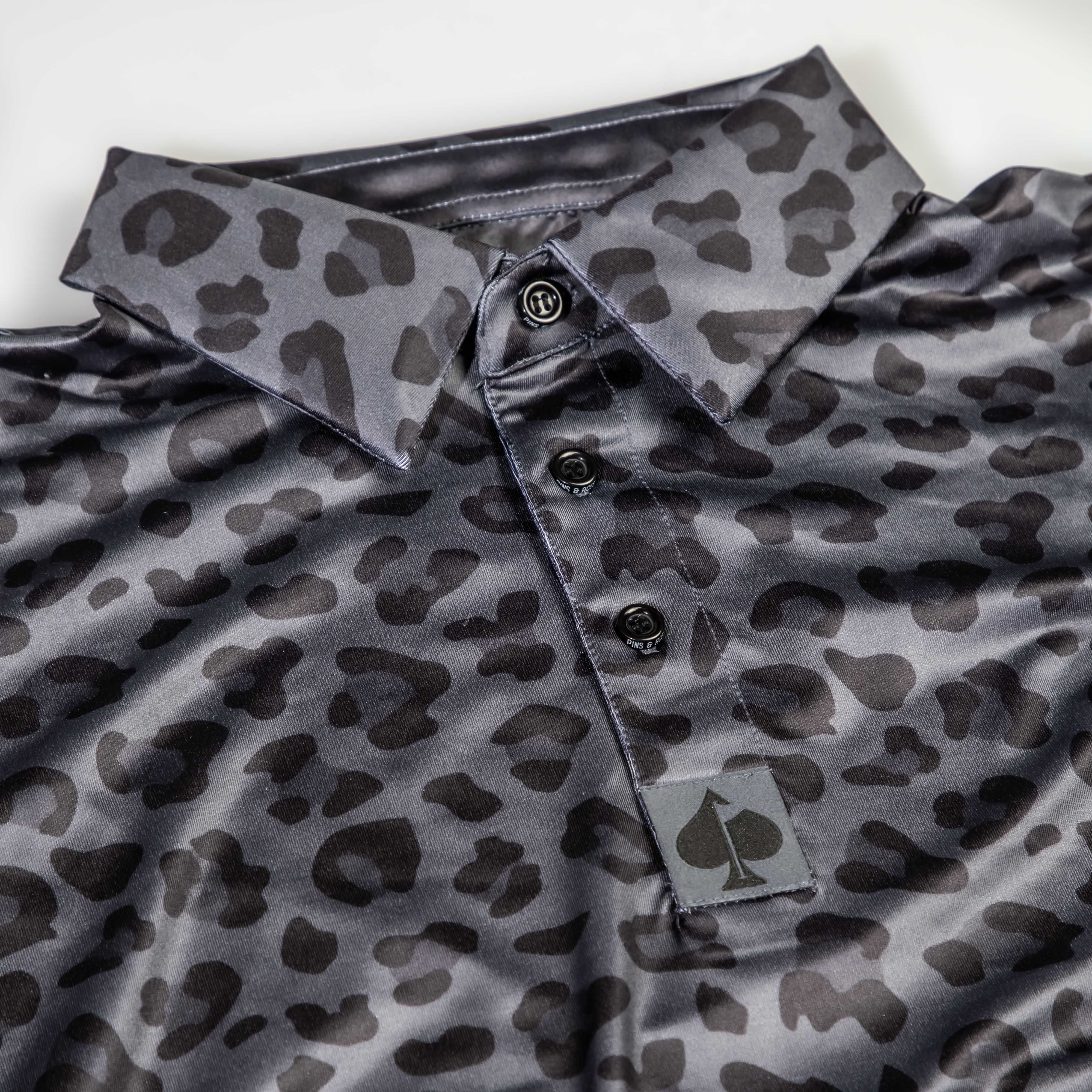 Bold black golf polo featuring a jungle cat print, designed for golfers who want to make a statement on the course.