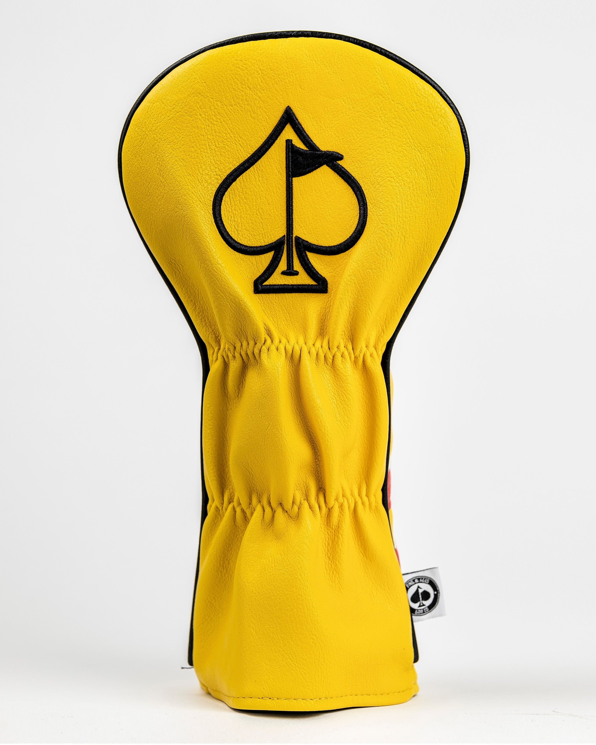 Bright yellow driver cover featuring a black spade logo, designed for golfers seeking a bold and unique accessory.